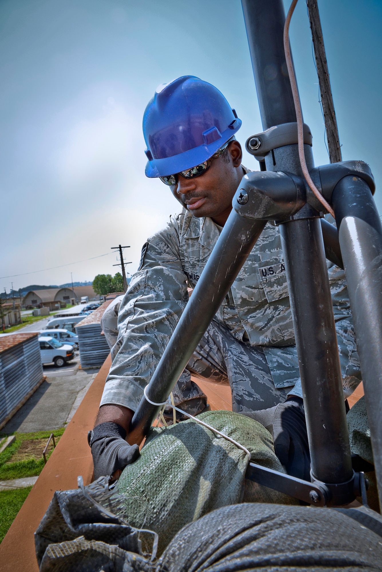 Tech. Sgt. Olandre L. Edwards, 644th Combat Communications Squadron radio frequency transmissions supervisor, adjusts sand bags on an antenna stand as part of a preventative-maintenance inspection to ensure reliable radio communications are maintained Aug. 27, 2015, at Suwon Air Base, Republic of Korea. The 644th CBCS is in place at Suwon AB from Andersen Air Force Base, Guam, to help set up and maintain temporary communications. (U.S. Air Force photo/Tech. Sgt. Travis Edwards)