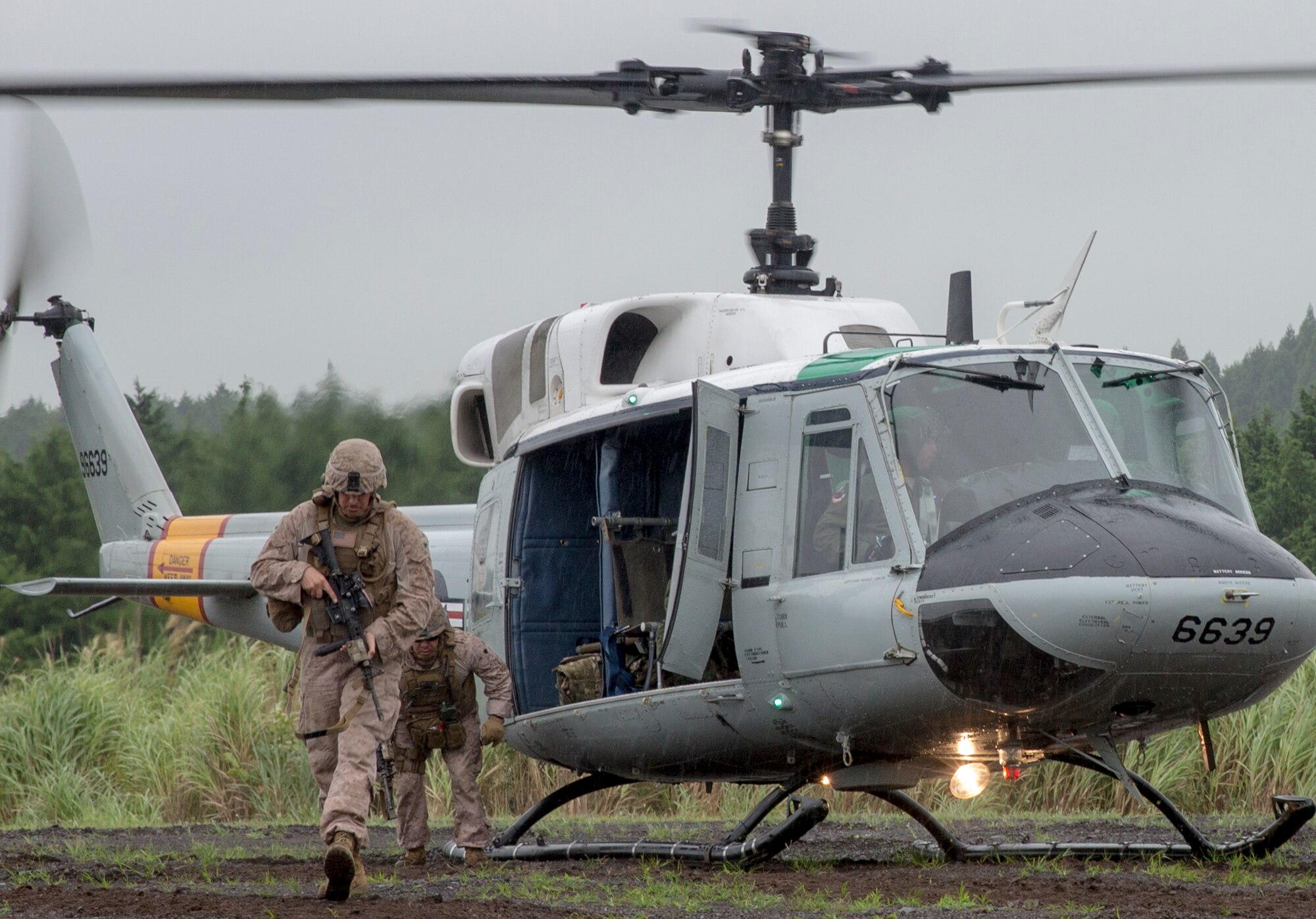 Combat Assault Battalion Marines with the 3rd Marine Division exit a UH-1N Iroquois during a joint exercise Iron Fist at Combined Arms Training Center Camp Fuji, Japan, Aug. 25, 2015. The UH-1N crewmembers participated in the joint exercise, providing an air asset for casualty evacuation and intelligence, surveillance and reconnaissance. The 459 AS regularly provides airlift capabilities in support of regional contingencies. (U.S. Air Force photo by Osakabe Yasuo/Released)