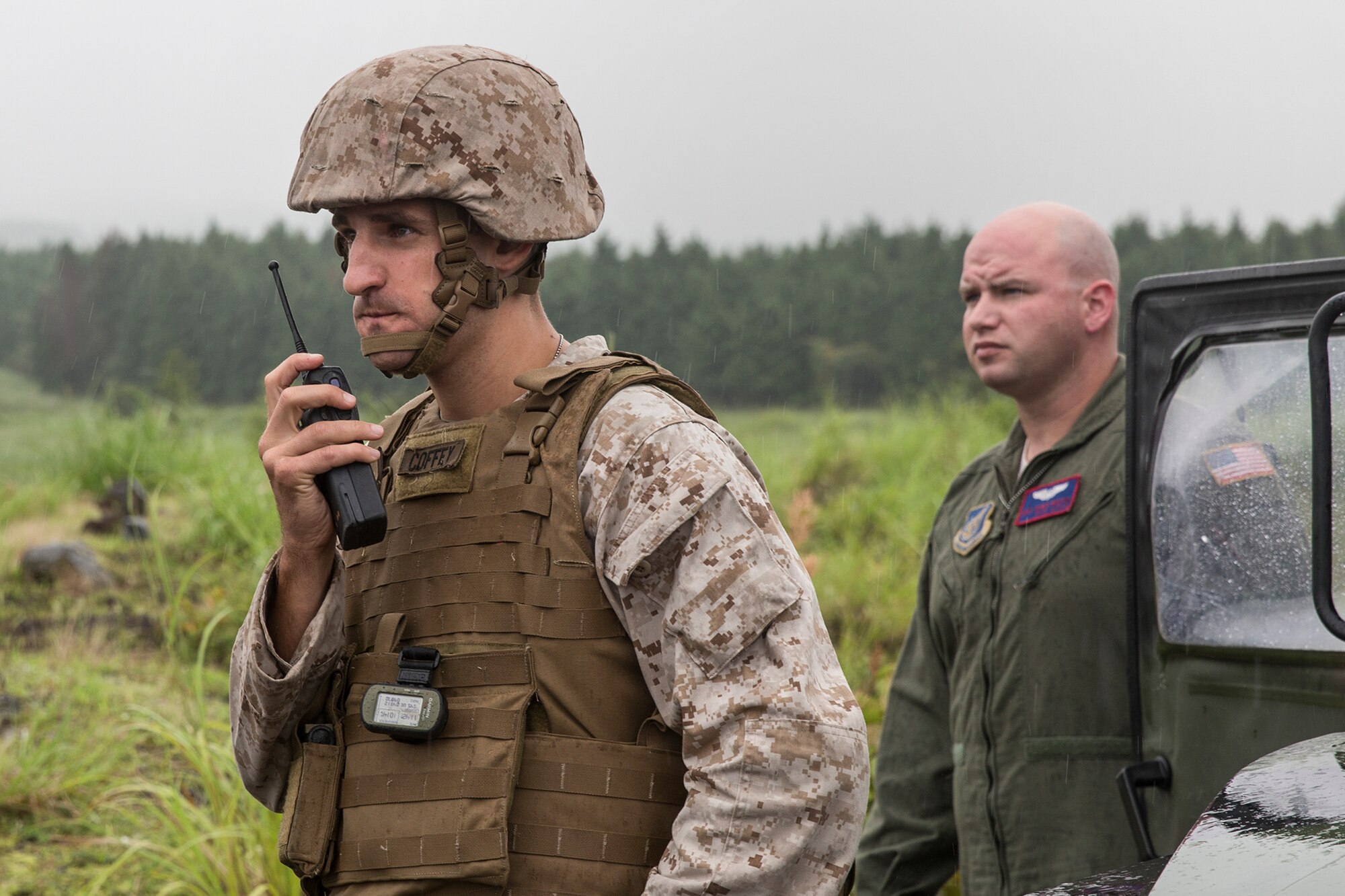 U.S. Marine Corps 1st Lt. Lawrence Coffey, Combat Assault Battalion, 3rd Marine Division, and U.S. Air Force Staff Sgt. Christopher Rector, 459th Airlift Squadron flight engineer, observe a UH-1N Iroquois takeoff at Combined Arms Training Center Camp Fuji, Japan, Aug. 25, 2015. The UH-1N crewmembers participated in the joint exercise, providing an air asset for casualty evacuation and intelligence, surveillance and reconnaissance. The 459 AS regularly provides airlift capabilities in support of regional contingencies. (U.S. Air Force photo by Osakabe Yasuo/Released)