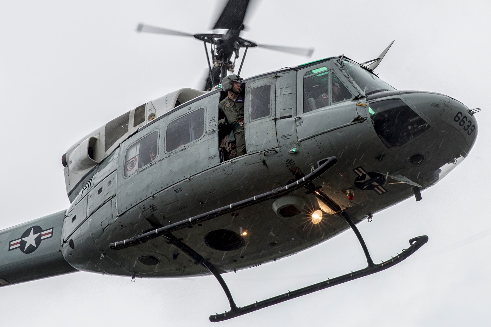 U.S. Air Force Staff Sgt. Nicholas Poe, 459th Airlift Squadron flight engineer, scans an area during Exercise Iron Fist at Combined Arms Training Center Camp Fuji, Aug. 25, 2015. The UH-1N crewmembers participated in the joint exercise, providing an air asset for casualty evacuation and intelligence, surveillance and reconnaissance. The 459 AS regularly provides airlift capabilities in support of regional contingencies. (U.S. Air Force photo by Osakabe Yasuo/Released)