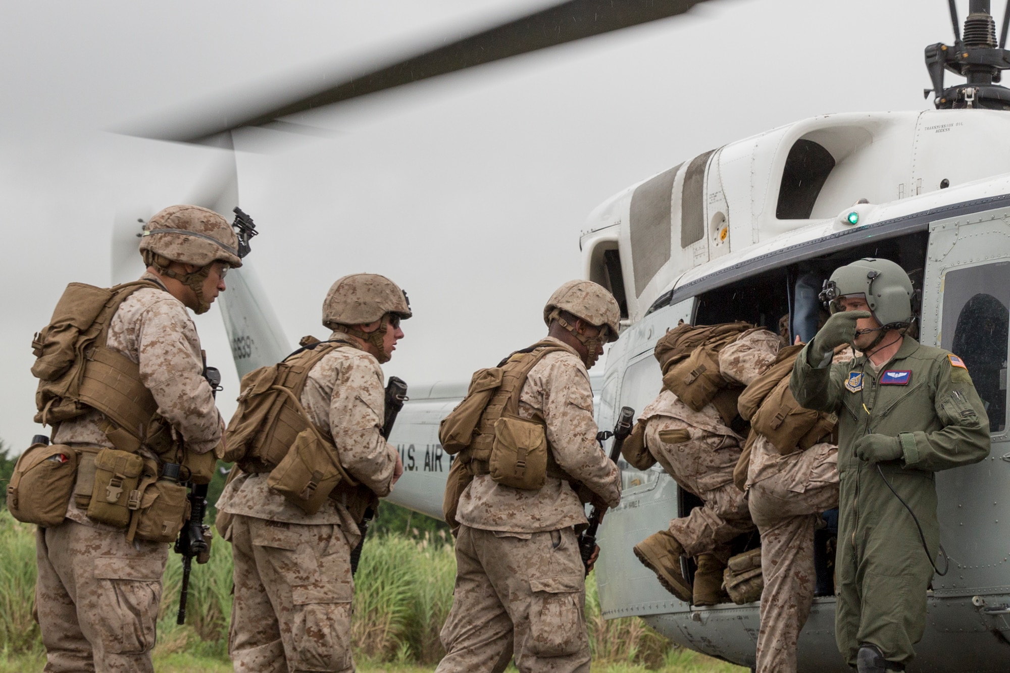 U.S. Air Force Staff Sgt. Nicholas Poe, 459th Airlift Squadron flight engineer, right, loads Combat Assault Battalion Marines with the 3rd Marine Division during Exercise Iron Fist at Combined Arms Training Center Camp Fuji, Aug. 25, 2015. The UH-1N crewmembers participated in the joint exercise, providing an air asset for casualty evacuation and intelligence, surveillance and reconnaissance. The 459 AS regularly provides airlift capabilities in support of regional contingencies. (U.S. Air Force photo by Osakabe Yasuo/Released)