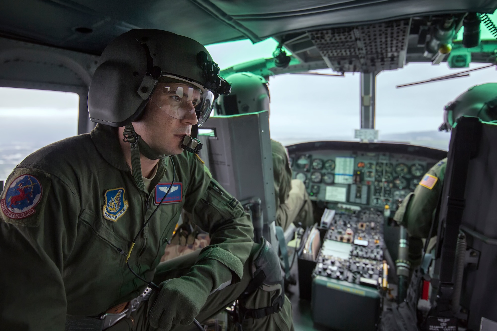 Staff Sgt. Nicholas Poe, 459th Airlift Squadron flight engineer, communicates with a pilot during Exercise Iron Fist over Combined Arms Training Center Camp Fuji, Japan, Aug. 25, 2015. The UH-1N crewmembers participated in the joint exercise, providing an air asset for casualty evacuation and intelligence, surveillance and reconnaissance. The 459 AS regularly provides airlift capabilities in support of regional contingencies. (U.S. Air Force photo by Osakabe Yasuo/Released)