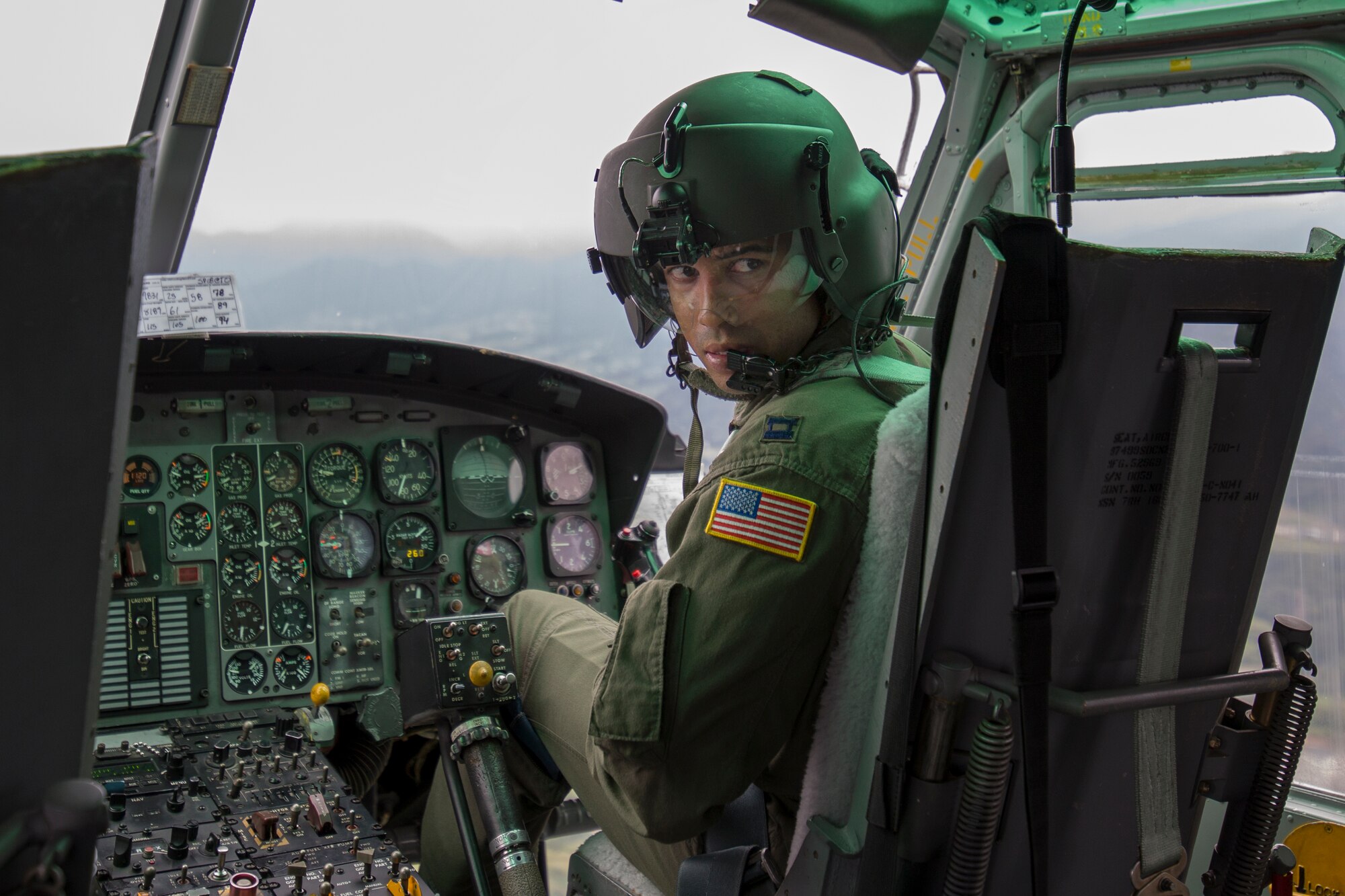 Capt. Brandon Jones, 459th Airlift Squadron UH-1N pilot, communicates with a flight engineer during an exercise at Combined Arms Training Center Camp Fuji, Japan, Aug. 25, 2015. The UH-1N crewmembers participated in Exercise Iron Fist, providing an air asset for casualty evacuation and intelligence, surveillance and reconnaissance. The 459 AS regularly provides airlift capabilities in support of regional contingencies. (U.S. Air Force photo by Osakabe Yasuo/Released)