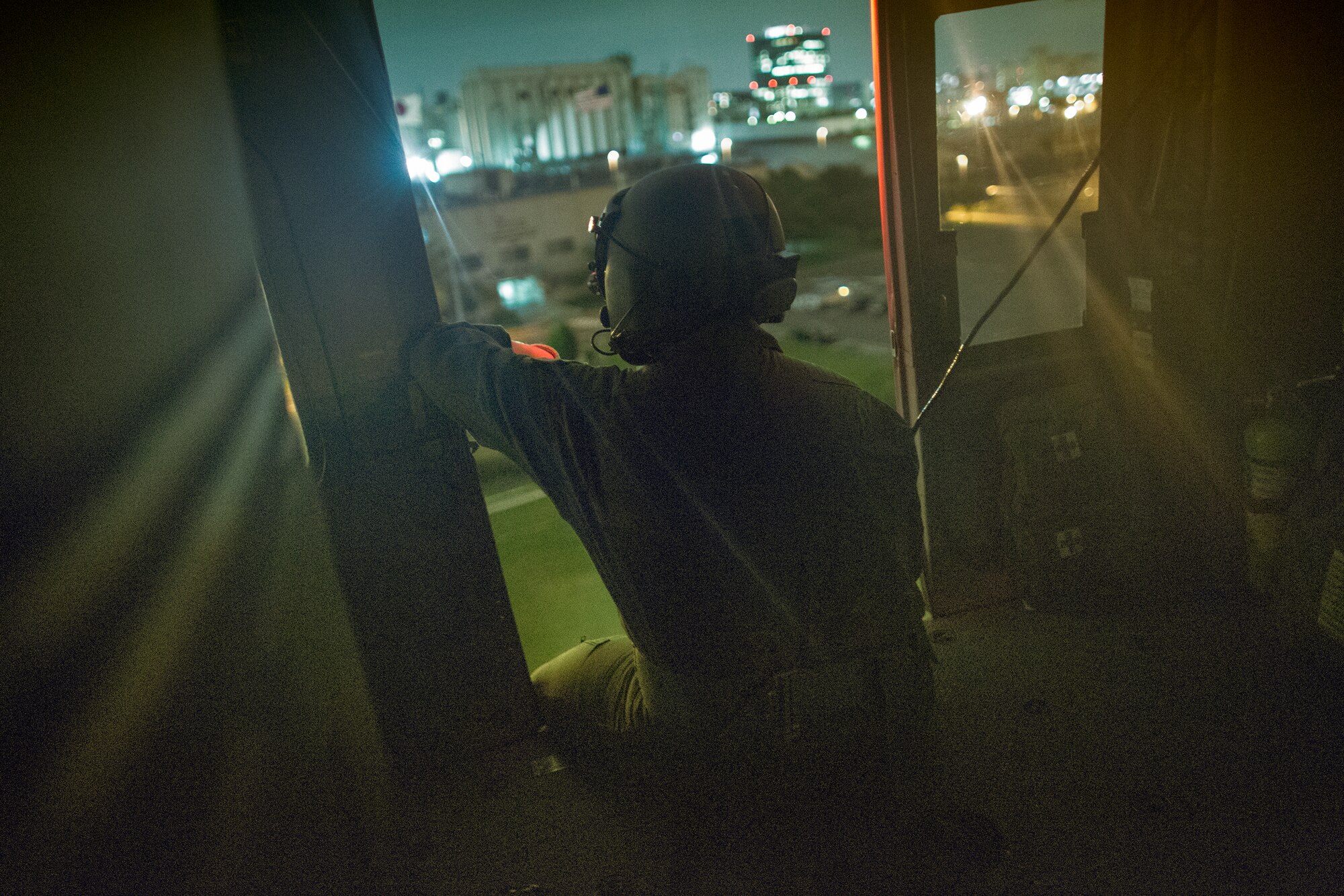Staff Sgt. Christopher Rector, 459th Airlift Squadron flight engineer, scans an area from an UH-1N Iroquois at Yokohama North Dock, Japan, Aug. 24, 2015. The UH-1N crewmembers participated in Exercise Iron Fist, providing an air asset for casualty evacuation and intelligence, surveillance and reconnaissance. The 459 AS regularly provides airlift capabilities in support of regional contingencies. (U.S. Air Force photo by Osakabe Yasuo/Released)