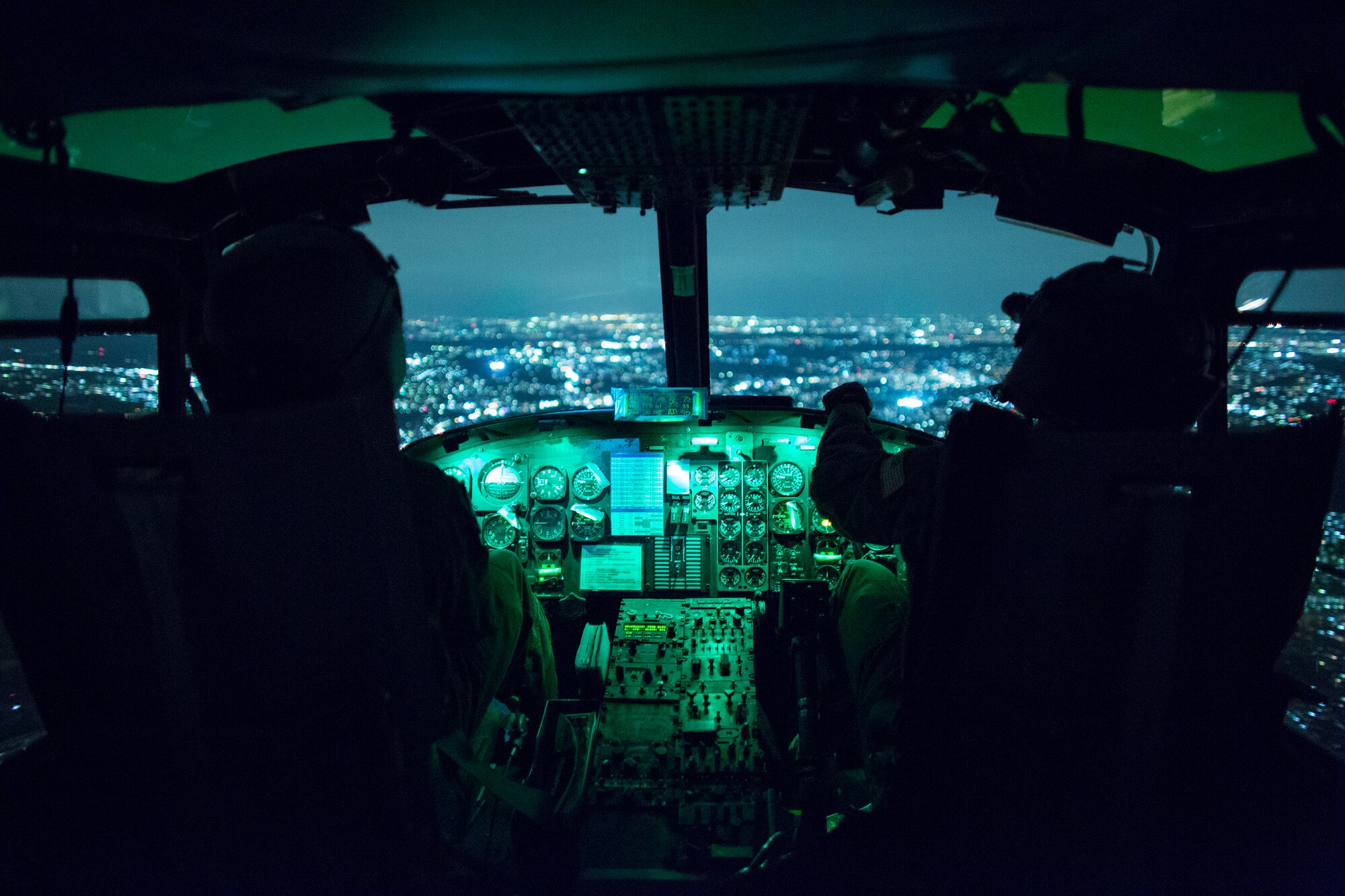 (Right to left) Capt. Brandon Jones and 1st Lt. Jonathan Palka, 459th Airlift Squadron UH-1N Iroquois pilots, use night vision goggles during an exercise above Yokota Air Base, Japan, Aug. 24, 2015. The UH-1N crewmembers participated in Exercise Iron Fist, providing an air asset for casualty evacuation and intelligence, surveillance and reconnaissance. The 459 AS regularly provides airlift capabilities in support of regional contingencies. (U.S. Air Force photo by Osakabe Yasuo/Released) 