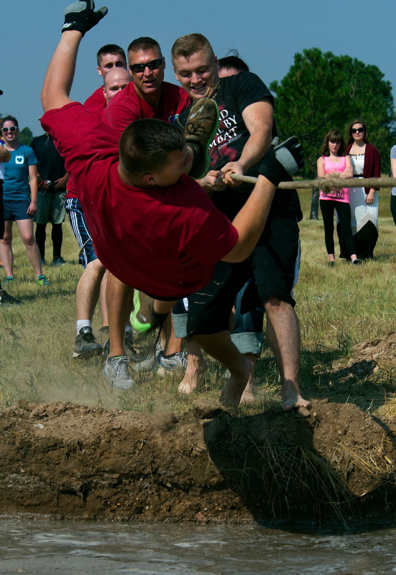 Daniel Davitt, 90th Medical Group, goes airborne into the mud hole when his team loses a tug-of-war match Aug. 21, 2015, during the annual Frontiercade festivities on F.E. Warren Air Force Base, Wyo. Each year, Airmen of the 90th Missile Wing and their families come together to compete in such events as horseshoes, volleyball and a buffalo-chip toss.  (U.S. Air Force photos by R.J. Oriez/Released)