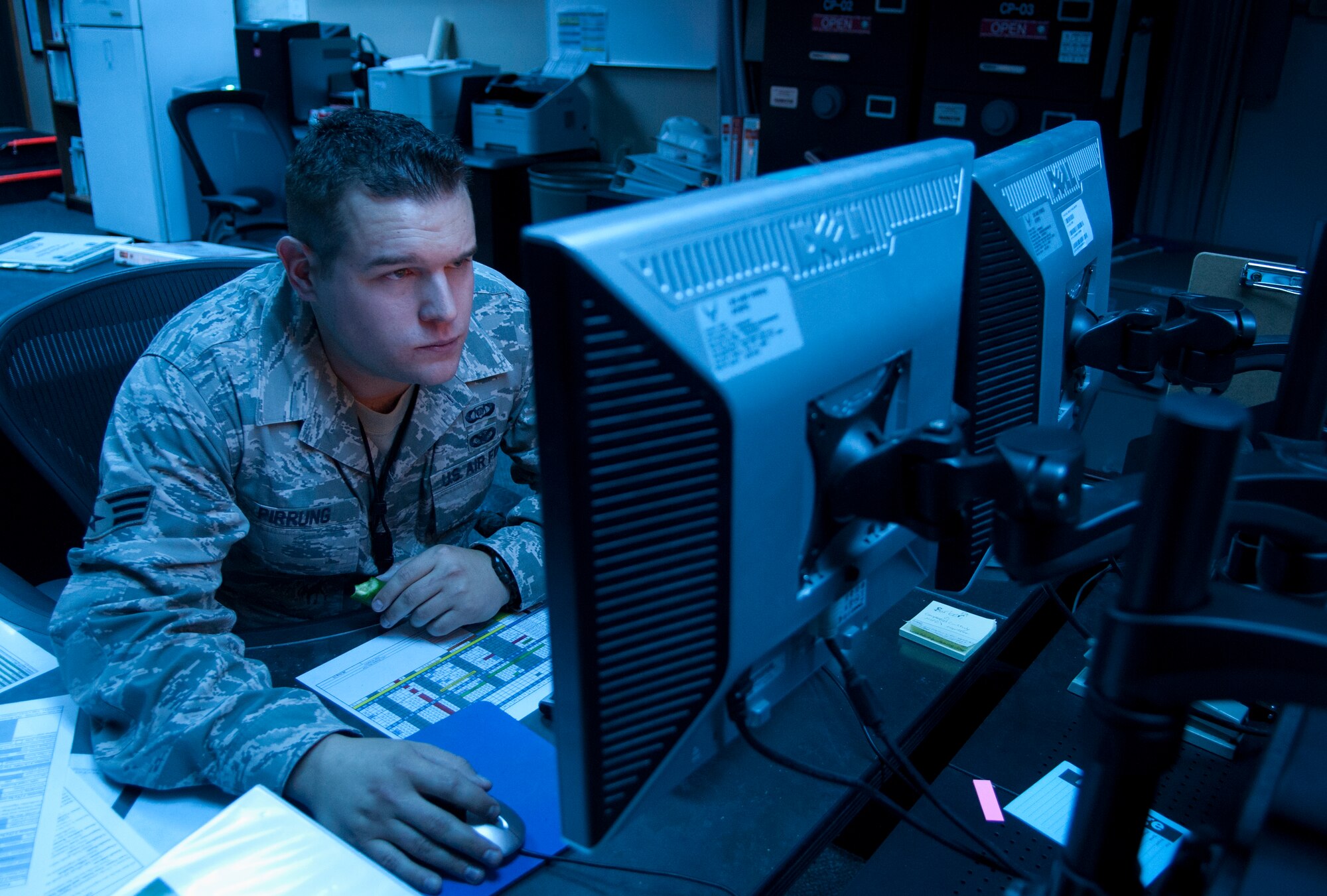Senior Airman Zachary Pirrung, 90th MW Command Post senior emergency action controller, mans the command post at 12:54 a.m., Aug. 25, 2015. Pirrung was one half of the two-person team making up the night shift. A minimum of two individuals are required to always be available in the office 24/7, 365 days a year. (U.S. Air Force photo by Airman 1st Class Malcolm Mayfield)