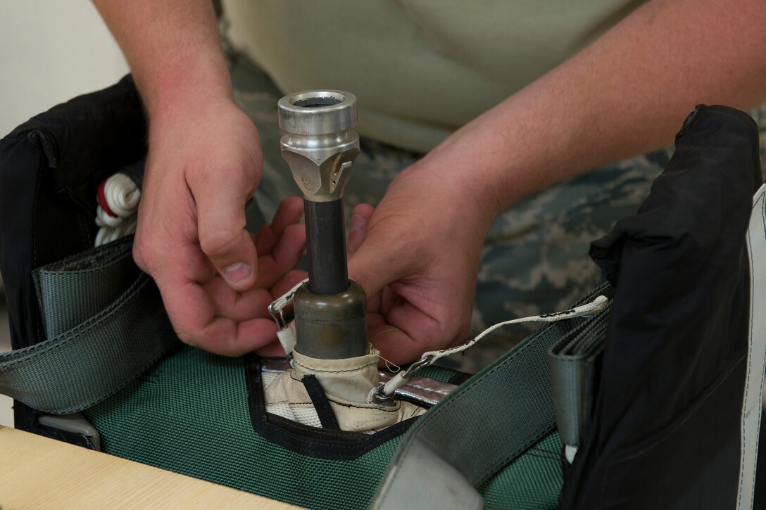 A 23d Operations Support Squadron aircrew flight equipment journeyman inspects the mortar tube on a parachute container Aug. 19, 2015, at Moody Air Force Base, Ga. The mortar tube launches a pilot’s seat out when ejecting from an aircraft. (U.S. Air Force photo by Airman 1st Class Kathleen D. Bryant/Released)
