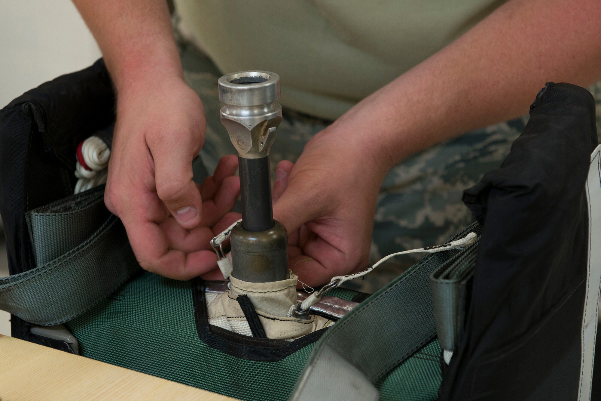 A 23d Operations Support Squadron aircrew flight equipment journeyman inspects the mortar tube on a parachute container Aug. 19, 2015, at Moody Air Force Base, Ga. The mortar tube launches a pilot’s seat out when ejecting from an aircraft. (U.S. Air Force photo by Airman 1st Class Kathleen D. Bryant/Released)
