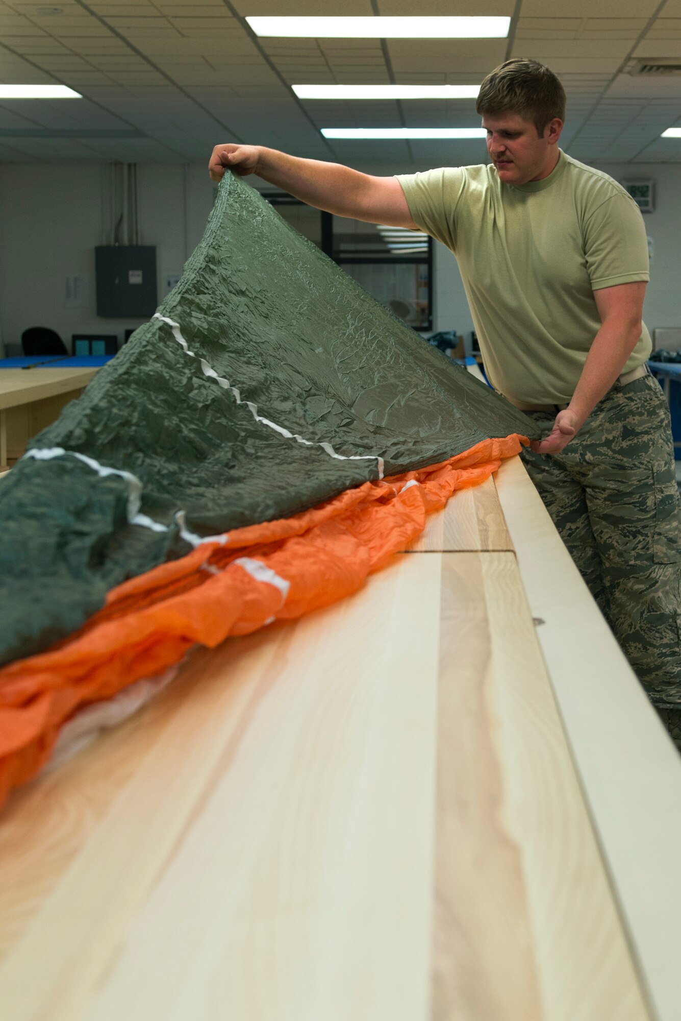 U.S. Air Force Senior Airman Jonathan Kunkle, 23d Operations Support Squadron aircrew flight equipment journeyman, inspects a parachute for damage Aug. 19, 2015, at Moody Air Force Base, Ga. AFE personnel repack parachutes not in use during yearly inspections to ensure the equipment is safe. (U.S. Air Force photo by Airman 1st Class Kathleen D. Bryant/Released)
