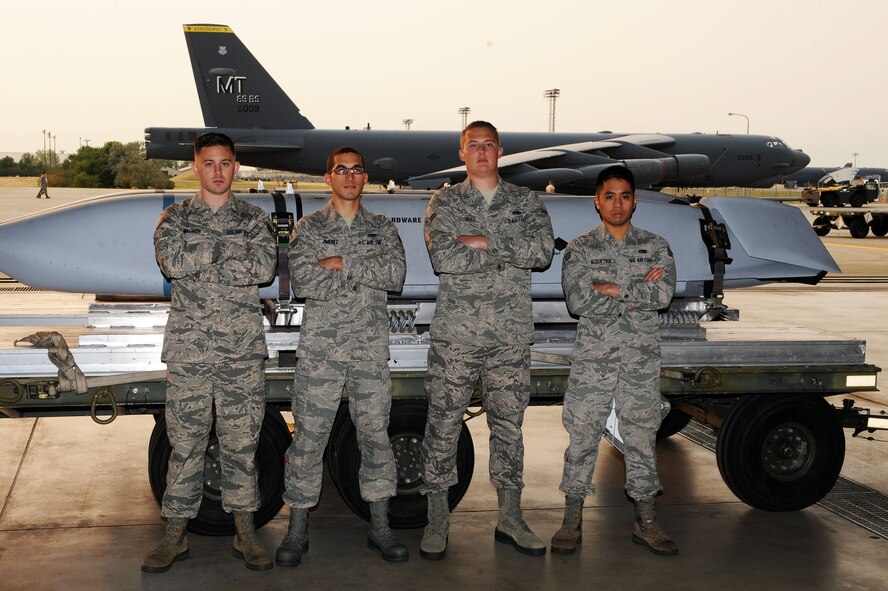 From left to right, Staff Sgt. Robert Wagner, Senior Airman Alex Jimenez, Airman 1st Class James Rutt and Senior Airman Ryandolph Alquetra, 5th Aircraft Maintenance Squadron nuclear/conventional weapons load team, pose in front of a missile at Minot Air Force Base, N.D., Aug. 21, 2015. During the Global Strike Challenge, the team will be doing a conventional load as well as a bay load. They have been practicing every day by practicing loading, going over Air Force instructions, transferring bombs and loading repetitively to prepare for the challenge. They are very confident they have what it takes to win. (U.S. Air Force photo / Senior Airman Kristoffer Kaubisch)