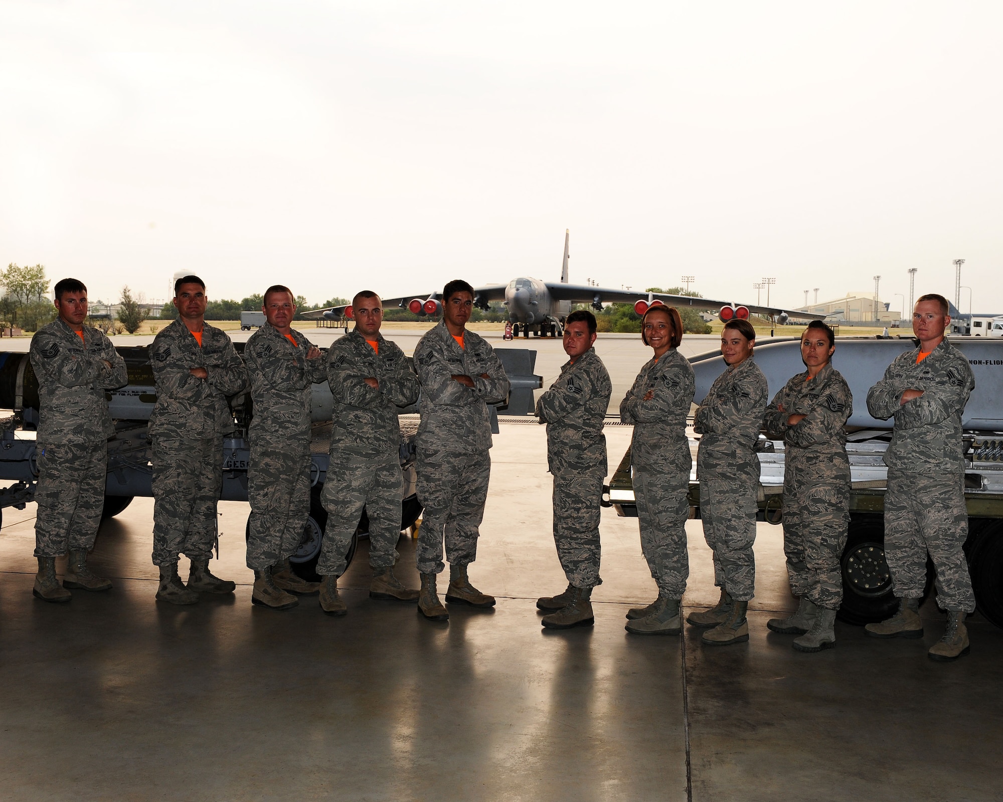From left to right, Tech Sgt. Christopher Butterfield, Staff Sgt. Daniel Tondre, Senior Airman Tadd Meyer, Senior Airman Tyler St Onge, Senior Airman Kody Regelbrugge, Senior Airman John Shaffer, Airman 1st Class Megan Tinch, Airman 1st Class Devon Stearns, Staff Sgt. Amber Stepan and Senior Airman Roddy Looper, 5th Munitions Squadron nuclear/conventional weapons load team, pose in front of missiles at Minot Air Force Base, N.D., Aug. 21, 2015. This will be the first year anyone from this team has competed in the Global Strike Challenge. The team has been coming together quickly and is very confident in their abilities. They have come together as a team and have the loading down to an art. (U.S. Air Force photo / Senior Airman Kristoffer Kaubisch)