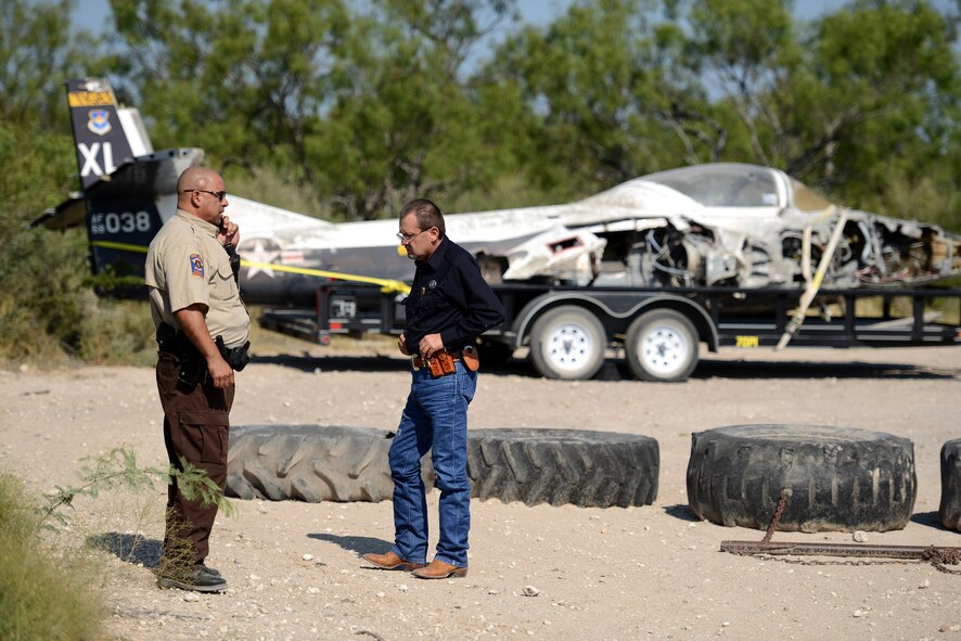 Ben Vasquez, left, and Javier Ibanez, Kinney County Sherriff Department deputy sheriffs, contact dispatch to verify cordon requirements at a major accident response exercise in Spofford, Texas, Aug. 26, 2015. When a military aircraft crashes or is forced to land on public or private property outside of military facilities, the local authorities having administrative jurisdiction over the area of the accident will provide necessary services, including rescue, first aid, evacuation, firefighting and restricting unauthorized persons from the immediate vicinity of the accident site. (U.S. Air Force photo by Tech Sgt. Steven R. Doty)(Released)