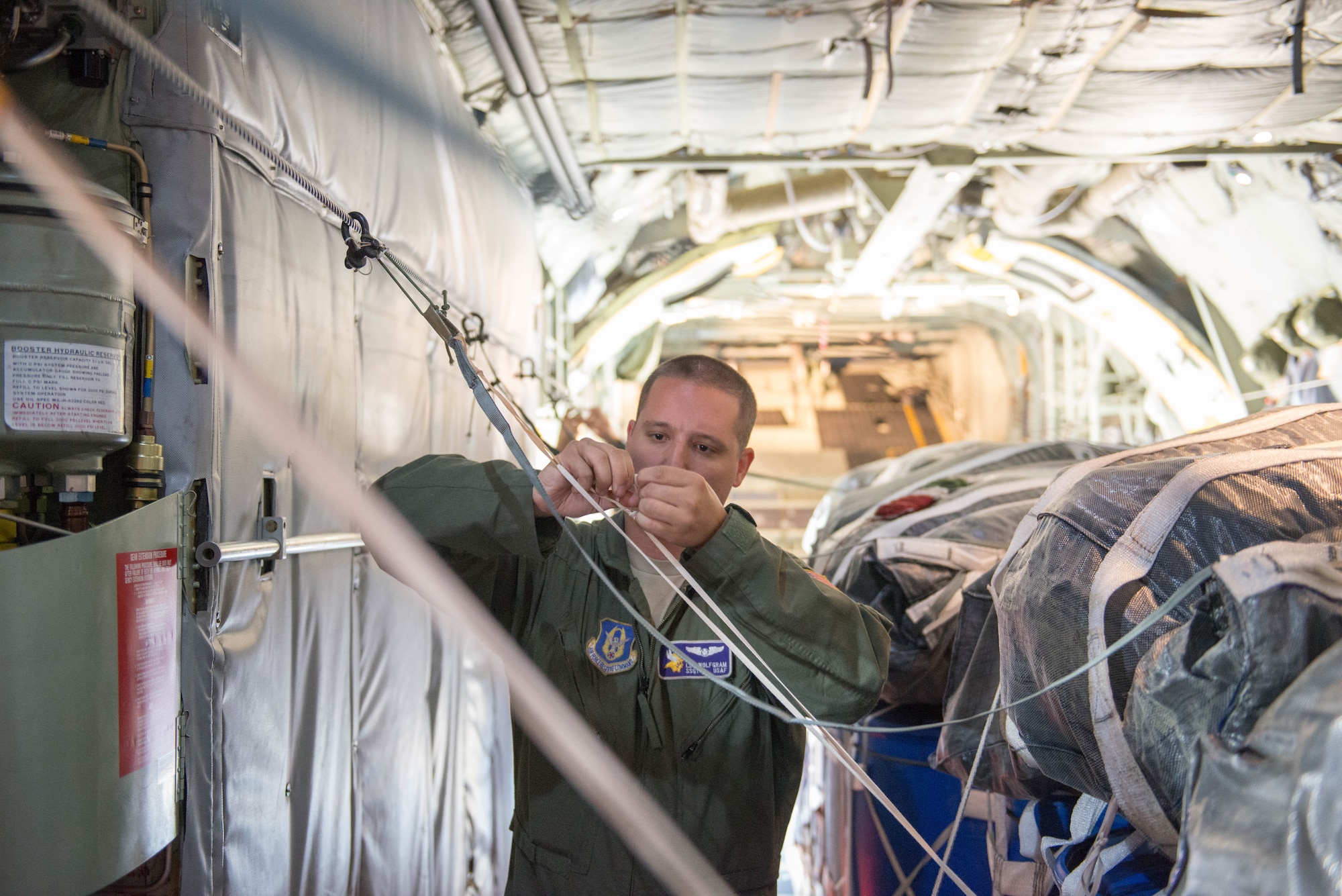 Staff Sgt. Lee Wolfgram, 96 AS loadmaster, prepares cargo for an airdrop during exercise Swift Response 15 at Ramstein AB, Germany. (U.S. Air Force Photo by Staff Sgt. Trevor Saylor/Released)