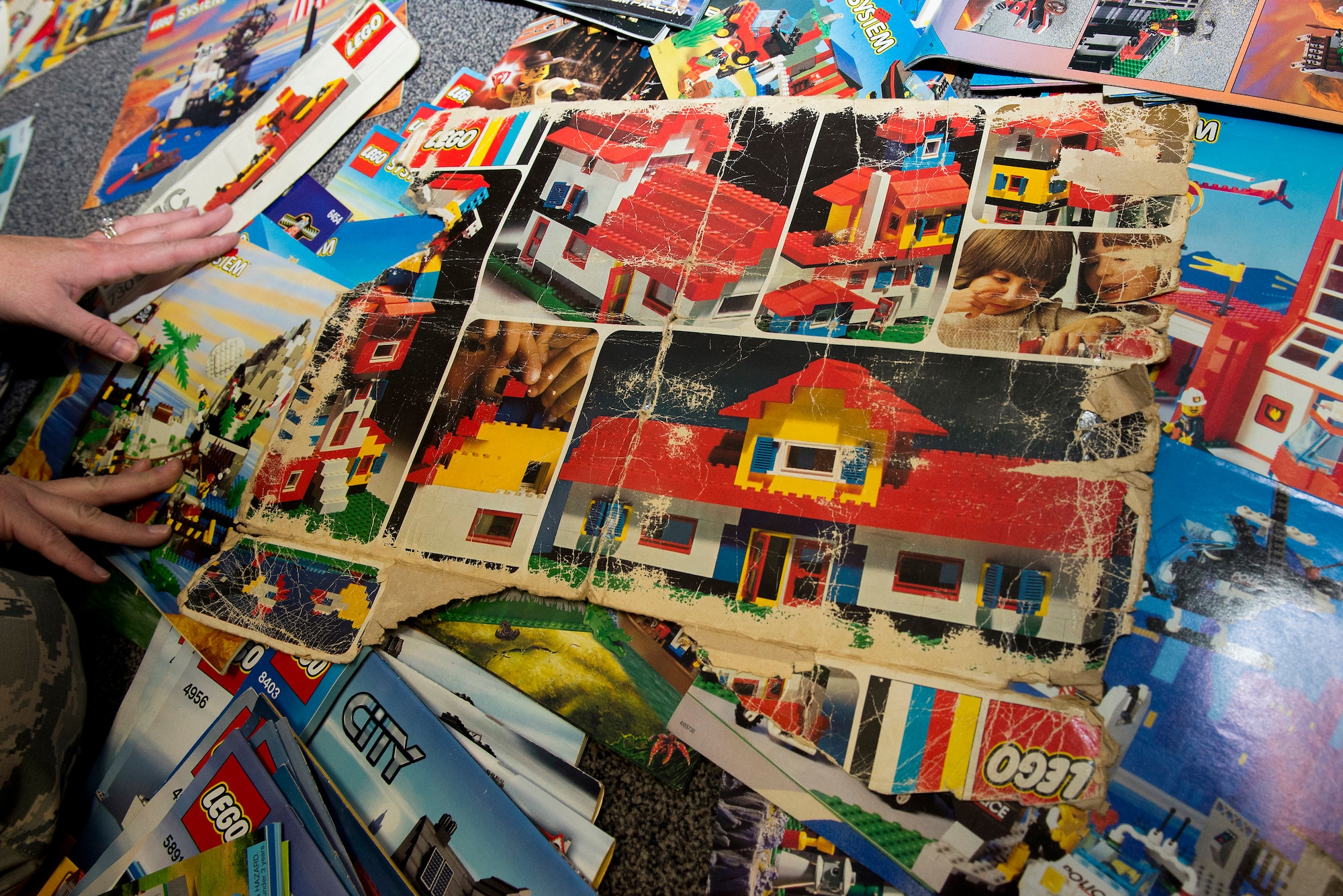 Lt. Col. Danielle Budzko sorts through her vintage Lego diagrams. Budzko owns many Legos from the 1970s to present day. (U.S. Air Force Photo by Senior Airman Megan Friedl)