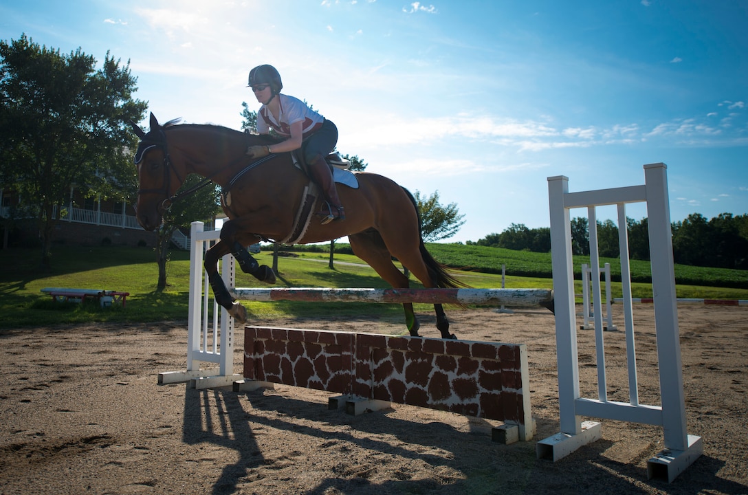 Capt. Lindsey Colburn, 11th Wing executive officer and her horse, Soon, jump over a hurdle on Leighton Farm, Upper Marlboro, Md., Aug. 21, 2015. Previously a racehorse, Soon has won several races but has since retired and now primarily jumps. (U.S. Air Force photo by Staff Sgt. Chad C. Strohmeyer)(Released)
