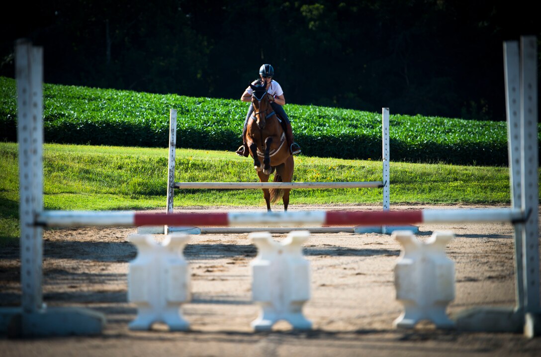 Capt. Lindsey Colburn, 11th Wing executive officer and her horse, Soon, jump over a hurdle on Leighton Farm, Upper Marlboro, Md., Aug. 21, 2015. Colburn has been riding horses since she was seven and owned her first horse when she was 12. (U.S. Air Force photo by Staff Sgt. Chad C. Strohmeyer)(Released)