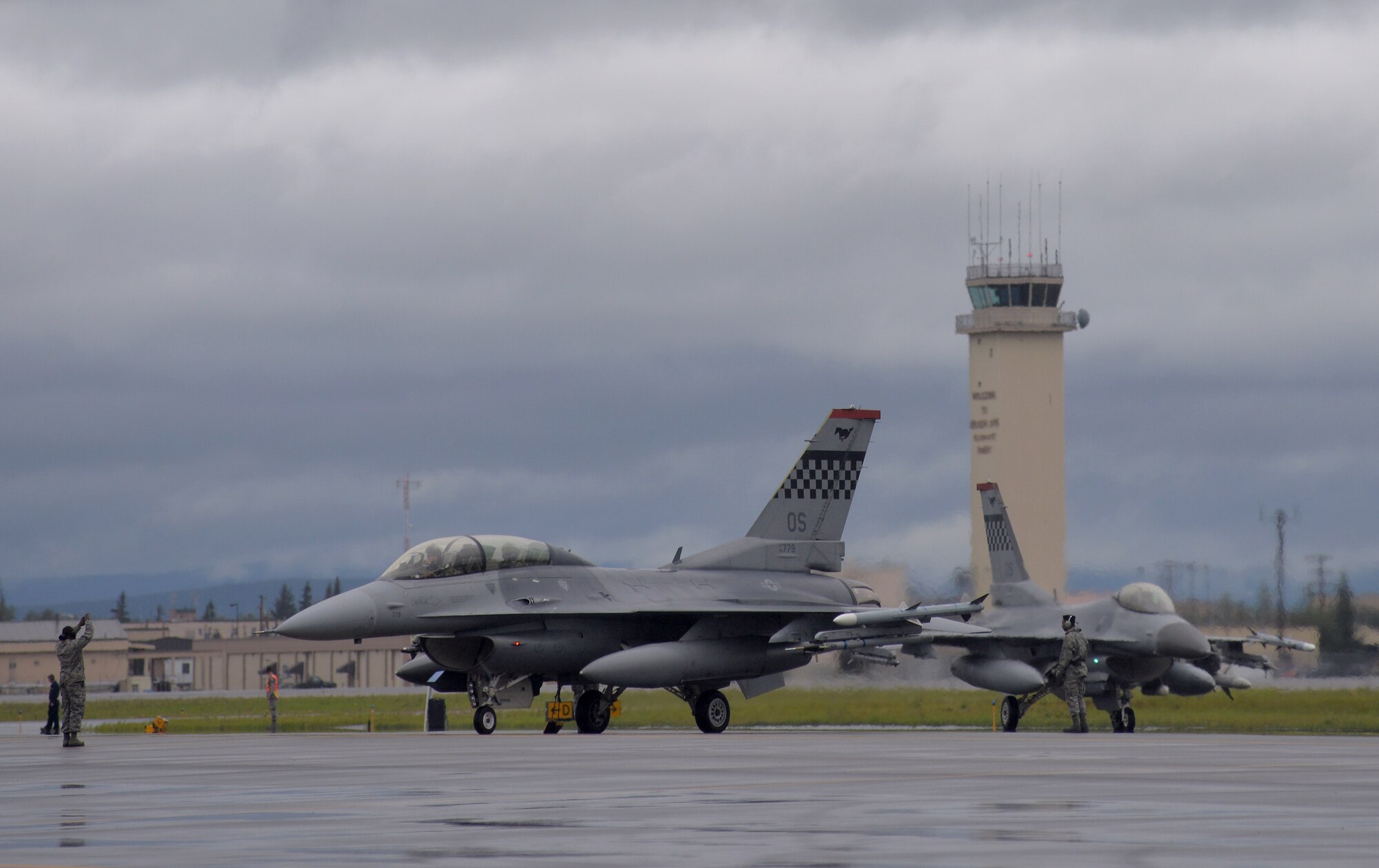 A U.S. Air Force crew chief lines up F-16 Fighting Falcons with the 36th Fighter Squadron from Osan Air Base, Republic of Korea, in preparation for the first simulated combat sortie of RED FLAG-Alaska (RF-A) 15-3 from Eielson Air Force Base, Alaska, Aug. 10, 2015. The Osan F-16s, as well as several A-10 Thunderbolt II aircraft from Osan's 25th Fighter Squadron, are deployed to Eielson for RF-A, a series of Pacific Air Forces commander-directed field training exercises for U.S. and partner nation forces, providing combined offensive counter-air, interdiction, close air support, and large force employment training in a simulated combat environment. (U.S. Air Force photo by Master Sgt. Karen J. Tomasik/Released)