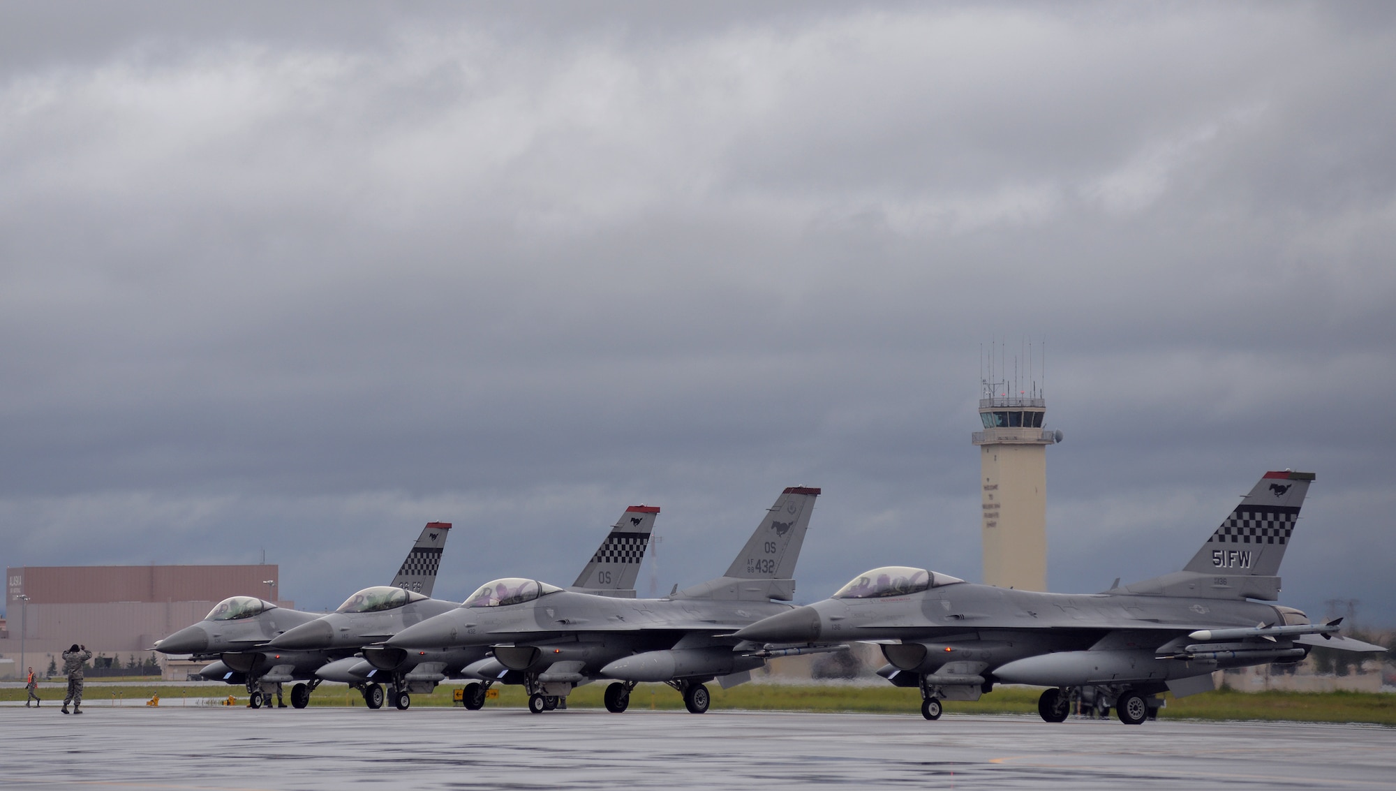 A U.S. Air Force crew chief lines up F-16 Fighting Falcons with the 36th Fighter Squadron from Osan Air Base, Republic of Korea, in preparation for the first simulated combat sortie of RED FLAG-Alaska (RF-A) 15-3 from Eielson Air Force Base, Alaska, Aug. 10, 2015. The Osan F-16s, as well as several A-10 Thunderbolt II aircraft from Osan's 25th Fighter Squadron, are deployed to Eielson for RF-A, a series of Pacific Air Forces commander-directed field training exercises for U.S. and partner nation forces, providing combined offensive counter-air, interdiction, close air support, and large force employment training in a simulated combat environment. (U.S. Air Force photo by Master Sgt. Karen J. Tomasik/Released)