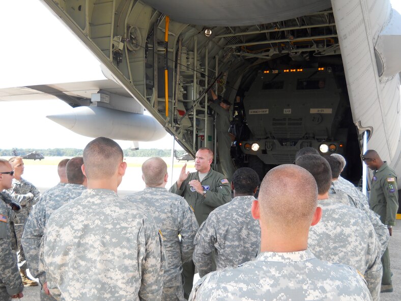 Senior Master Sgt. Dean Grothem, 96 Airlift Squadron loadmaster NCOIC, provides ground instruction to members of the Michigan Army National Guard on preparing the HIMARS for air transportation and how to properly secure vehicle in the aircraft. (Air Force Photo/Maj. Brandon Schrader/Released)