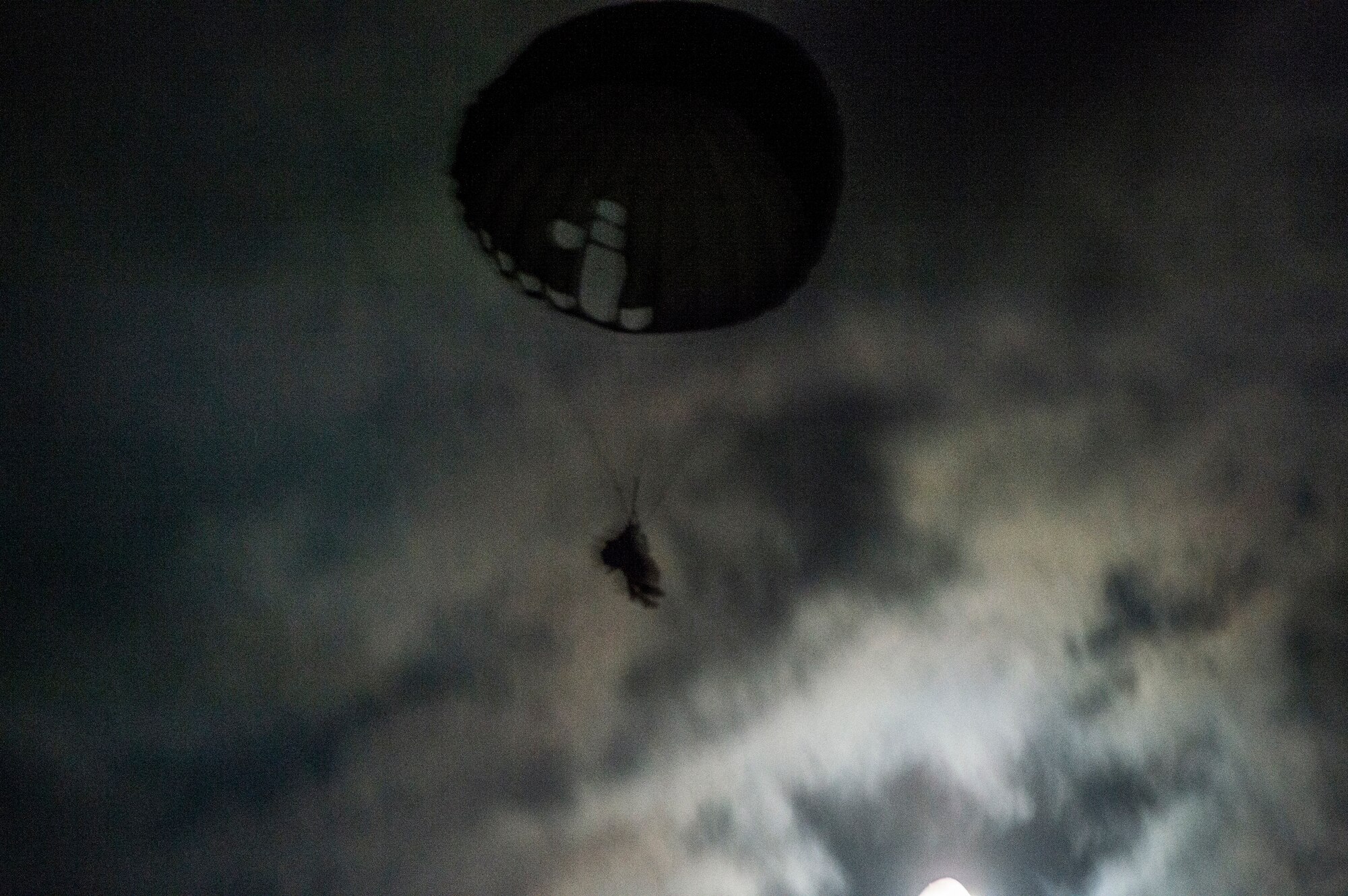An 820th Base Defense Group Airman descends to the ground after jumping from a HC-130J Combat King II during a night static-line drop August 25, 2015, at Moody Air Force Base, Ga. A static line is attached to the aircraft and automatically deploys the jumpers’ parachute after they’ve jumped. (U.S. Air Force photo by Staff Sgt. Eric Summers Jr./Released) 