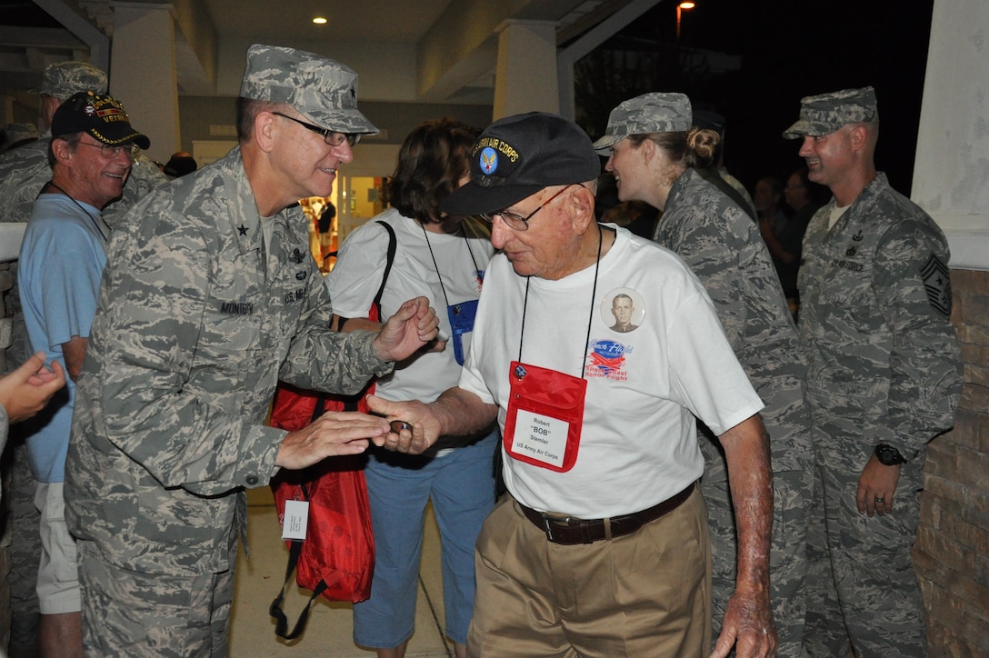 Brig. Gen. Wayne Monteith, 45th Space Wing commander, coins Robert Stemler, a veteran of the U.S. Army Air Corps, during an Honor Flight send-off event Aug. 22, 2015, at the Wickham Senior Center in Melbourne, Fla. Space Coast Honor Flight is an organization that provides World War II and Korean War Veterans an opportunity to visit their war memorials in Washington, D.C., on a one-day trip. (U.S. Air Force photo by 1st Lt. Alicia Premo/Released) 