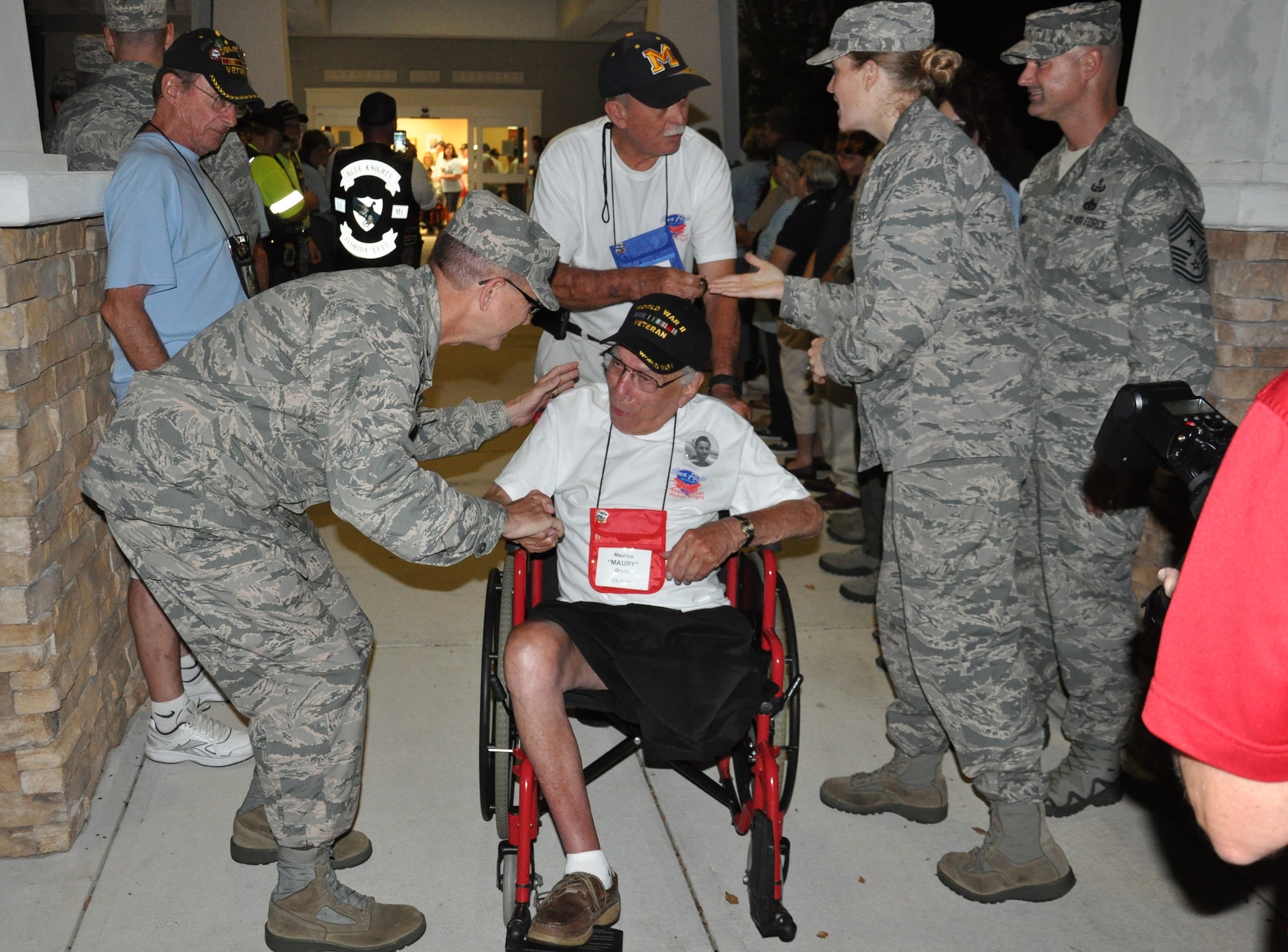 Brig. Gen. Wayne Monteith, 45th Space Wing commander, coins Maurice “Maury” Gralla, a veteran of the U.S. Navy, during an Honor Flight send-off event Aug. 22, 2015, at the Wickham Senior Center in Melbourne, Fla. Space Coast Honor Flight is an organization that provides World War II and Korean War Veterans an opportunity to visit their war memorials in Washington, D.C., on a one-day trip. (U.S. Air Force photo by 1st Lt. Alicia Premo/Released) 