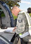 U.S. Air Force Tech. Sgt. Trey Sanders, 100th Civil Engineer Squadron Fire Department safety officer, runs an emergency checklist for an active shooter exercise Aug. 25, 2015, on RAF Mildenhall, England. The exercise was conducted to test 100th Security Forces Squadron, 100th Civil Engineer Squadron Fire Department and 48th Medical Group personnel on their response to an active shooter incident. (U.S. Air Force photo by Karen Abeyasekere/Released)