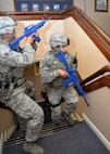 U.S. Air Force Senior Airman Dennis Schoomaker, left, 100th Security Forces Squadron combined controller, and U.S. Senior Airman Miguel Luna, 100th SFS response force leader, clear a building as they search for a simulated active shooter during an exercise Aug. 25, 2015, on RAF Mildenhall, England. The exercise was conducted to test 100th SFS, 100th Civil Engineer Squadron Fire Department and 48th Medical Group personnel on their response to an active shooter incident. (U.S. Air Force photo by Karen Abeyasekere/Released)
