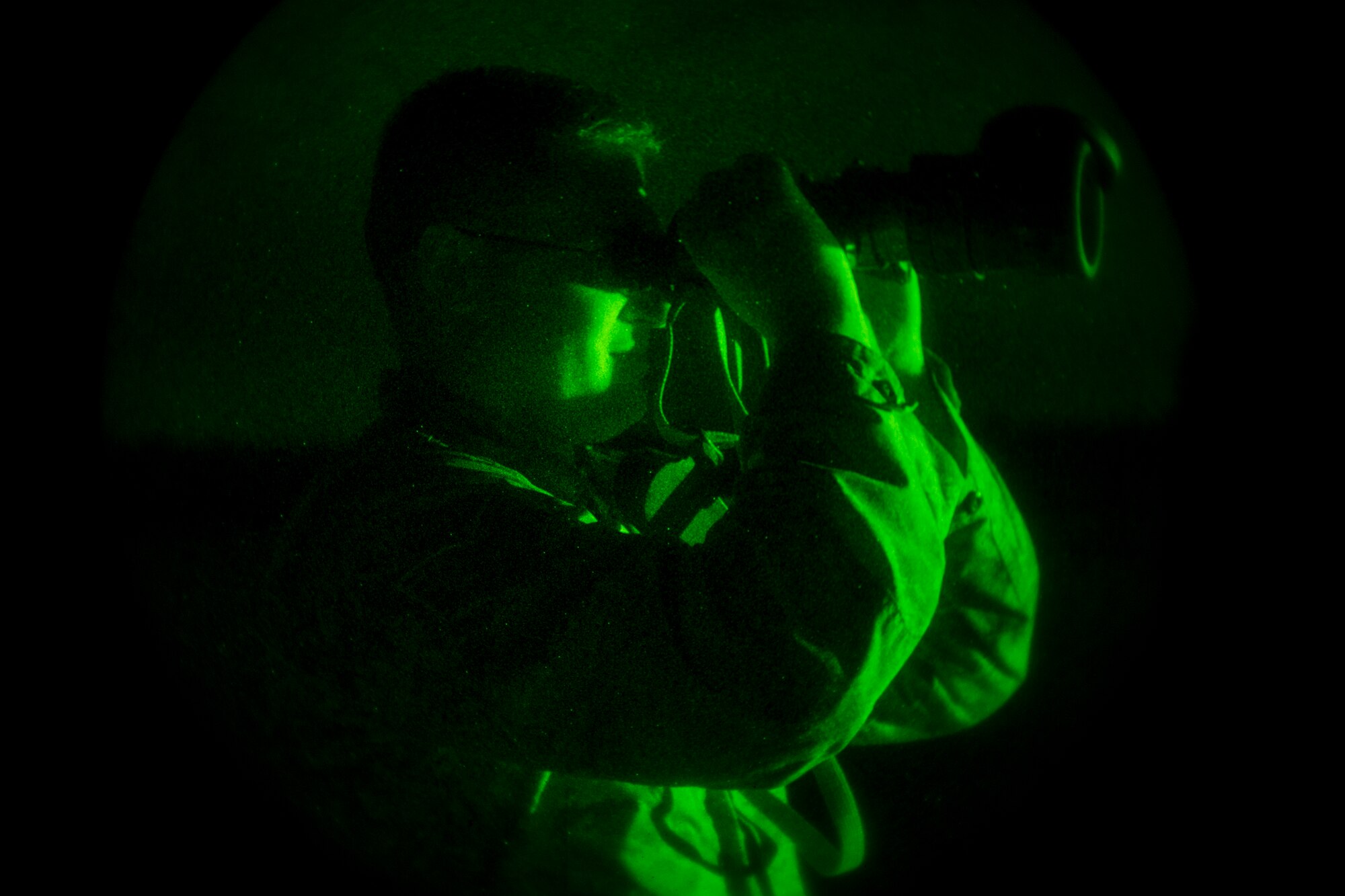 U.S. Air Force Staff Sgt. Corey Stickelman, 820th Combat Operations Squadron aircrew flight equipment craftsman, utilizes night-vision goggles during a static line combat-equipment jump Aug. 25, 2015, on Grand Bay Bombing and Gunnery Range at Moody Air Force Base, Ga. Stickelman used night vision to ensure the drop zone, where parachutes should land, was clear for the 13 participating jumpers. (U.S. Air Force photo by Airman 1st Class Ceaira Tinsley/Released)