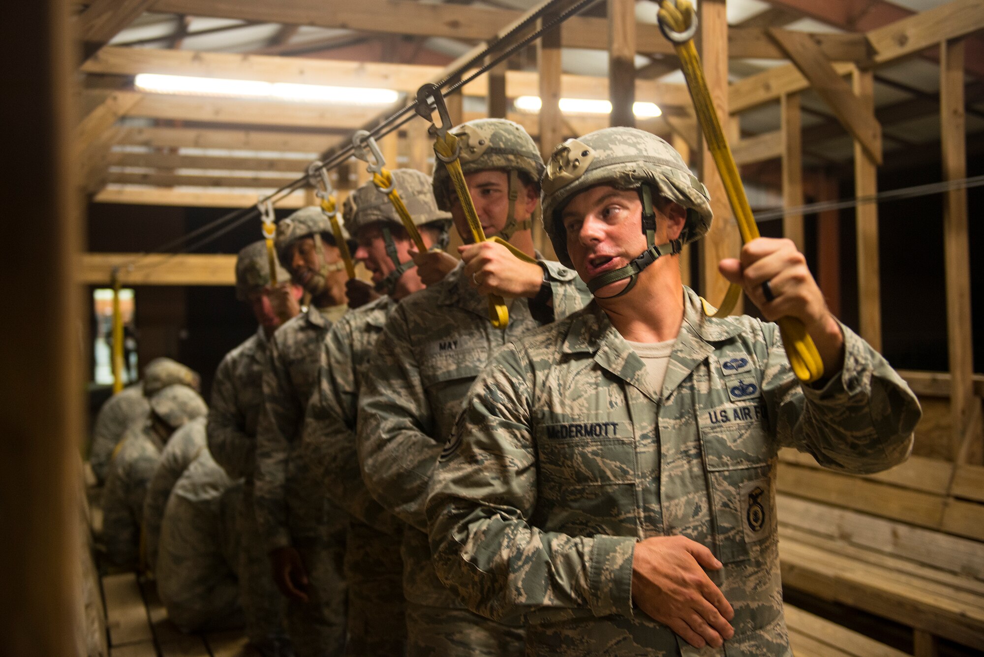 Airmen from the 820th Base Defense Group perform pre-jump training in a mock C-17 Globemaster III Aug. 25, 2015, at Moody Air Force Base, Ga. The training helps Airmen prepare for static-line jumps in an effort to maintain their jump qualifications. (U.S. Air Force photo by Airman 1st Class Ceaira Tinsley/Released)