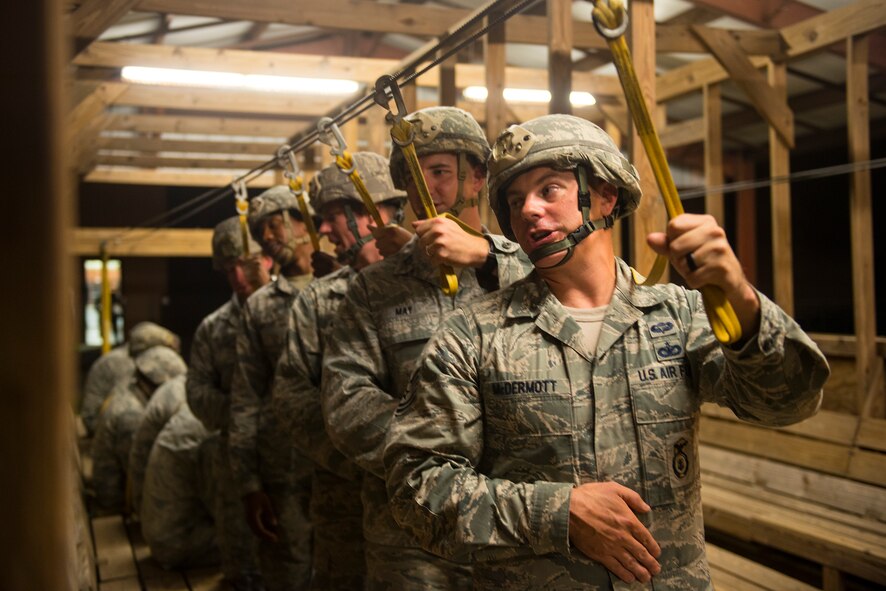 Airmen from the 820th Base Defense Group perform pre-jump training in a mock C-17 Globemaster III Aug. 25, 2015, at Moody Air Force Base, Ga. The training helps Airmen prepare for static-line jumps in an effort to maintain their jump qualifications. (U.S. Air Force photo by Airman 1st Class Ceaira Tinsley/Released)