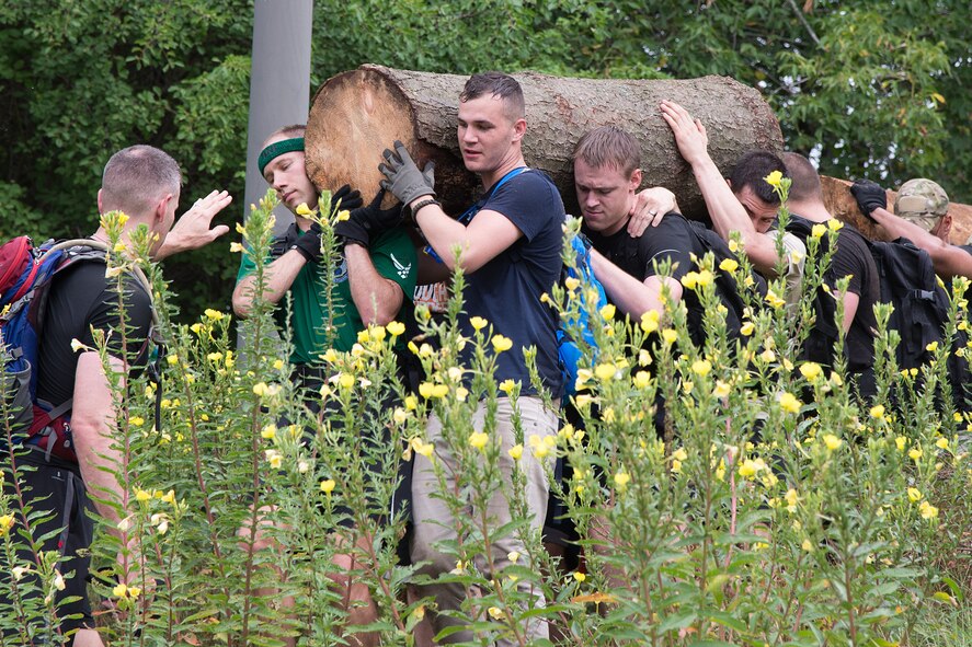 Hanscom Airmen carry a log through an obstacle during the Team Cohesion Challenge on base Aug. 24. The event was hosted by the 66th Force Support Squadron and provided Airmen with an opportunity to work as a team while incorporating the pillars of Comprehensive Airman Fitness. (U.S. Air Force photo by Mark Herlihy)