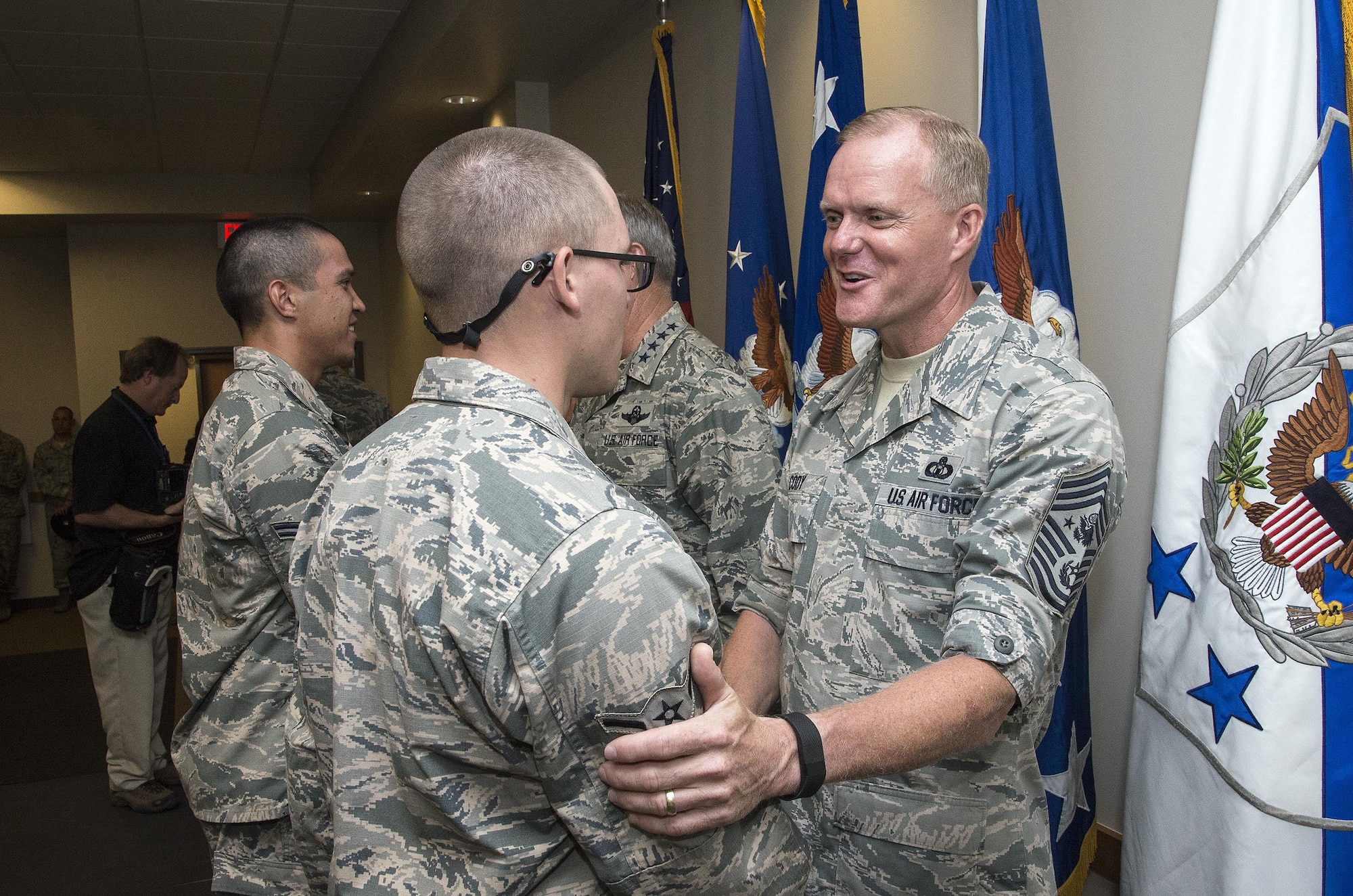 Chief Master Sergeant of the Air Force James A. Cody congratulates an Airman attending Airmen’s Week Aug. 27, 2015, at Joint Base San Antonio-Lackland’s Pfingston Reception Center. The Airmen received a copy of "America's Air Force: A Profession of Arms," the next evolution of the "Little Blue Book" previously released in 1997. The new book gives Airmen instant access to the core values, codes and creeds that guide Airmen as they serve in the Profession of Arms. The book will be distributed to all new Airmen before transitioning to technical training and available online through Air Force e-publishing. (U.S. Air Force photo by Johnny Saldivar/Released)  