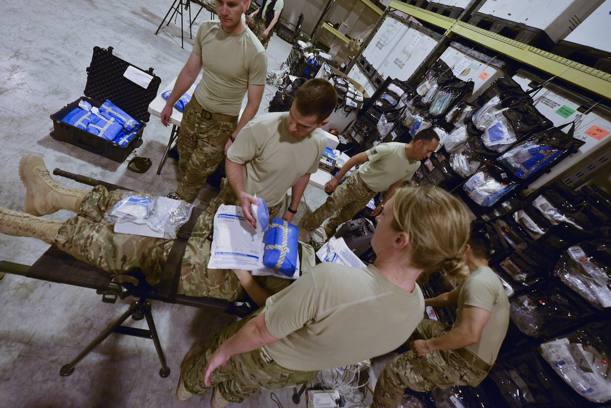 Airmen part of the 379th Expeditionary Medical Group Mobile Field Surgical Team discuss the actions and supplies needed during a timed training scenario to help with familiarization training August 28, 2015 at Al Udeid Air Base, Qatar. (U.S. Air Force photo/Staff Sgt. Alexandre Montes)