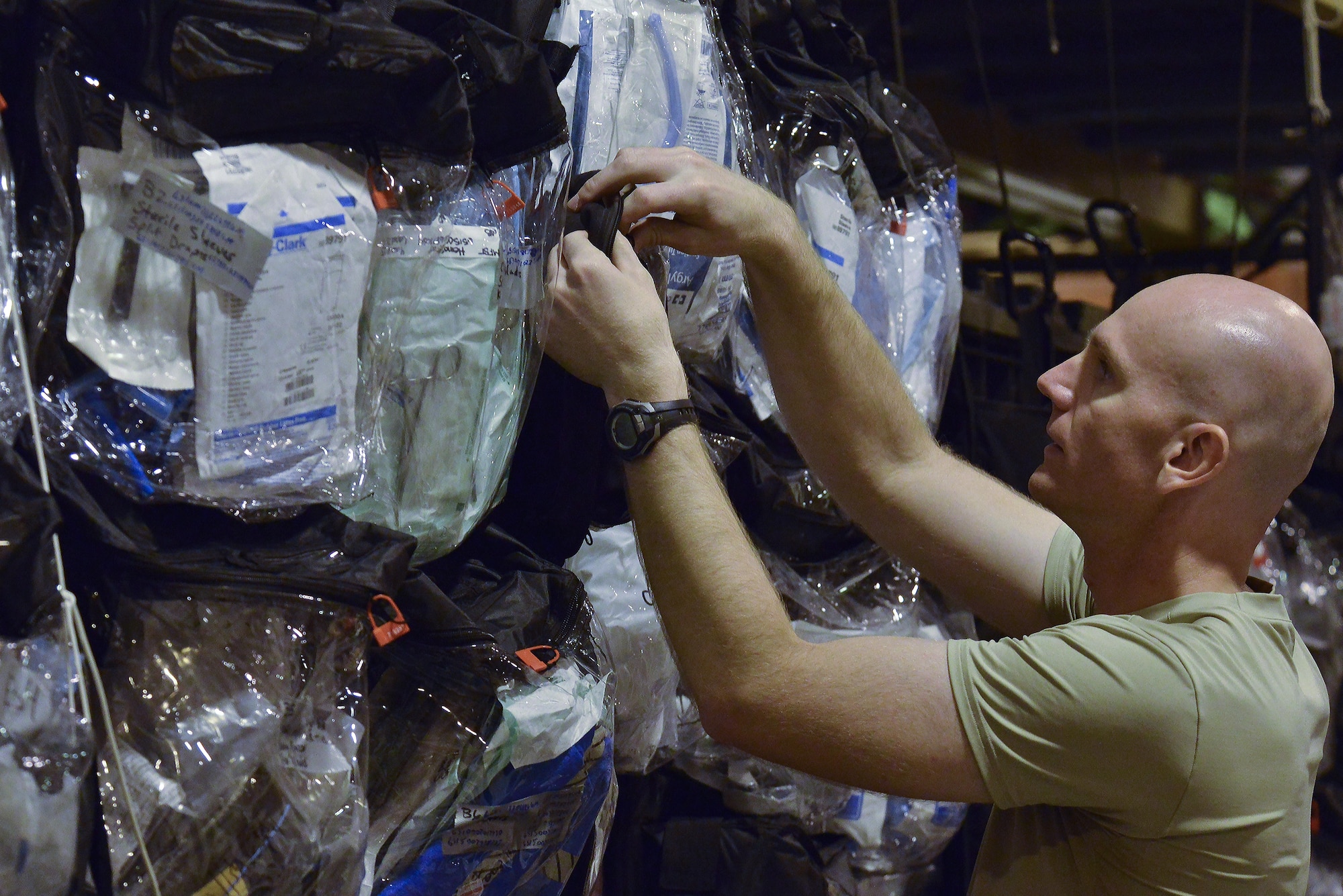 Capt. Brandon Trappett, 379th Expeditionary Medical Group Mobile Field Surgical Team, searches for the correct medical supplies for his team to complete a timed setup and equipment familiarization training August 28, 2015 at Al Udeid Air Base, Qatar. (U.S. Air Force photo/Staff Sgt. Alexandre Montes)