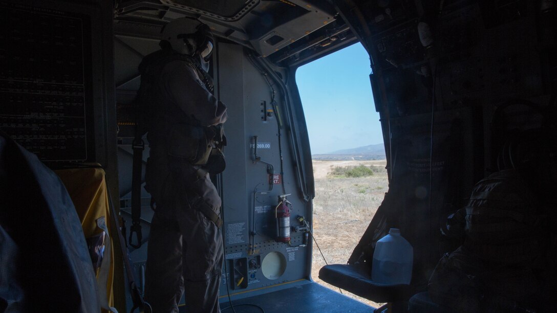 Gunnery Sgt. Paul Gallion, a flight line division chief and weapons and tactics instructor with Marine Medium Tiltrotor Squadron (VMM) 166 (Reinforced), watches as an MV-22B Osprey lands during a Tactical Recovery of Aircraft and Personnel mission aboard Marine Corps Base Camp Pendleton California, Aug. 18. Marines conducted a casualty evacuation drill as part of the 13th Marine Expeditionary Unit predeployment training. 