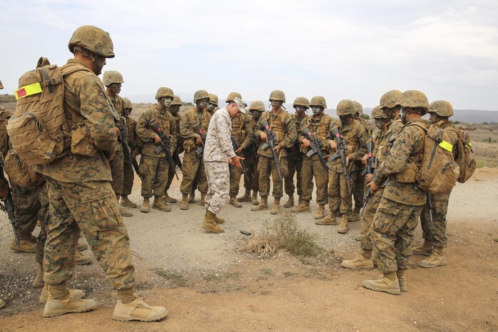 A field instructor with weapons and field training battalion, teaches the recruits not to pick up any loose gear found while searching for improvised explosive devices during the Crucible at Edson Range, Marine Corps Base Camp Pendleton, Aug. 25. They learned about the explosives through a walk down trail known as IED Lane. This event at the Crucible takes recruits down a path and through a small market place. Simulated IEDs are placed at various location along the way, including one filled with talcum powder that can be triggered by remote and trip wires. Today, all males recruited from west of the Mississippi are trained at MCRD San Diego. The depot is responsible for training more than 16,000 recruits annually and Alpha Company will graduate recruit training Sept. 4.