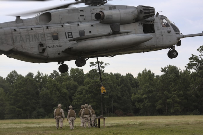 Marine pilots in a CH-53E Super Stallion with Marine Heavy Helicopter Training Squadron 302, descend into the landing zone toward Marines with 2nd Transportation Support Battalion during an external lift exercise aboard Camp Lejeune, N.C., Aug. 25, 2015. As the CH-53E hovered several yards above, on-the-ground Marines worked together to attach a beam weighing 8,500 pounds to the aircraft’s cable. (U.S. Marine Corps photo by Cpl. Paul S. Martinez/Released)