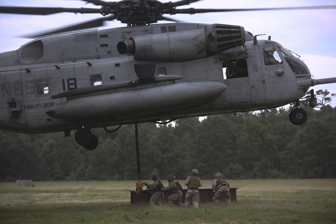 Marines with 2nd Transportation Support Battalion prepare to attach an 8,500-pound high beam to a pintle hook beneath a CH-53E Super Stallion during an external lift exercise aboard Camp Lejeune, N.C., Aug. 25, 2015. The 8,500 pound beam is only a fraction of the maximum 32,000 pounds the aircraft is capable of carrying. (U.S. Marine Corps photo by Cpl. Paul S. Martinez/Released)