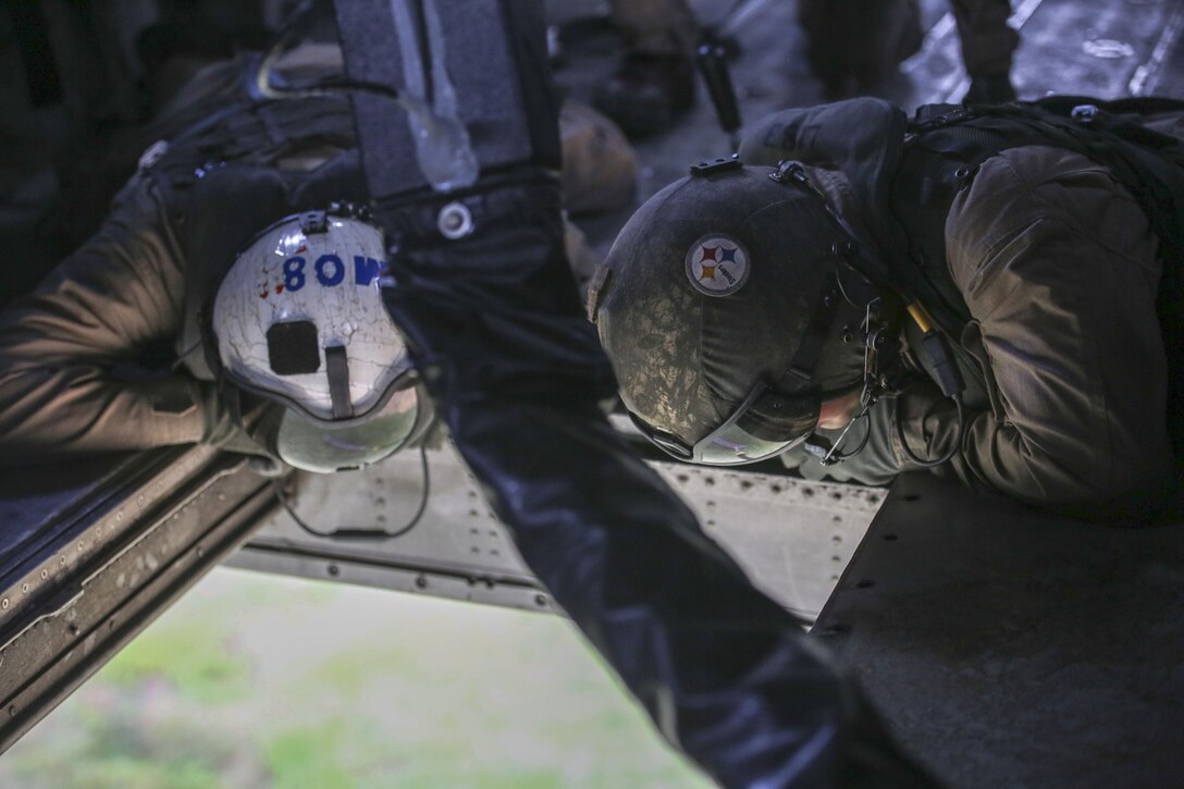Marine air crew with Marine Heavy Helicopter Training Squadron 302 oversees ground Marines from within a CH-53E Super Stallion during an external lift exercise aboard Camp Lejeune, N.C., Aug. 25, 2015. The air crew within carefully observed the ground team to ensure they securely attached their 8,500-pound high beam to a pintle hook below. (U.S. Marine Corps photo by Cpl. Paul S. Martinez/Released)