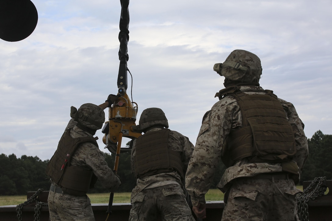 Marines with 2nd Transportation Support Battalion attach an 8,500-pound high beam to a pintle hook beneath a CH-53E Super Stallion during an external lift exercise aboard Camp Lejeune, N.C., Aug. 25, 2015. As the CH-53E hovered several yards above, on-the-ground Marines worked together to attach a beam weighing 8,500 pounds to the aircraft’s cable. (U.S. Marine Corps photo by Cpl. Paul S. Martinez/Released)