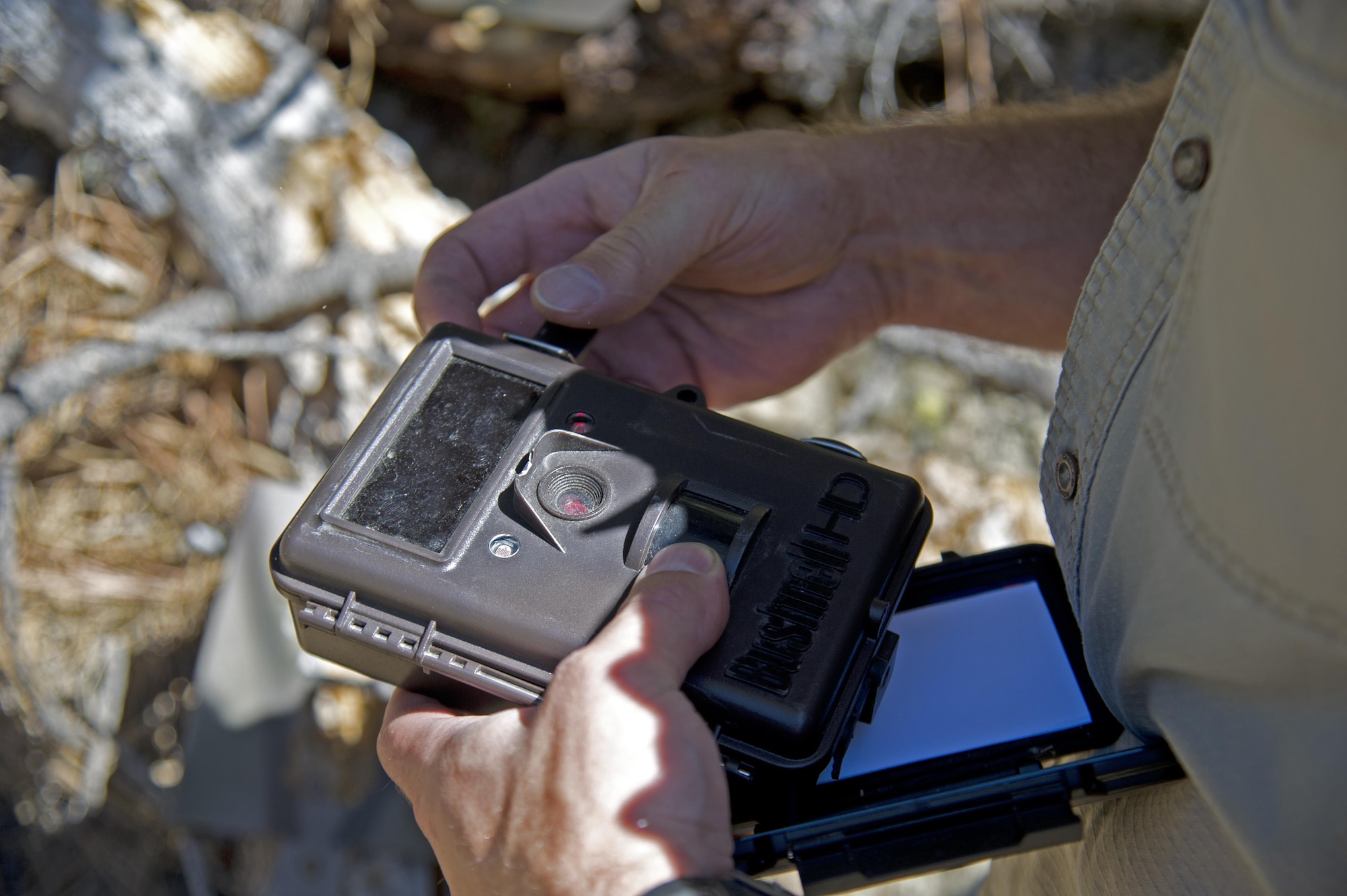 Todd Foster, the 336th Training Group training area manager, unlocks a case containing a trail camera July 29, 2015, at Colville National Forest, Wash. Foster assists the U.S. Forest Service and the U.S. Air Force Survival School by tracking animals within the school training area. (U.S. Air Force photo/Airman 1st Class Nicolo J. Daniello)