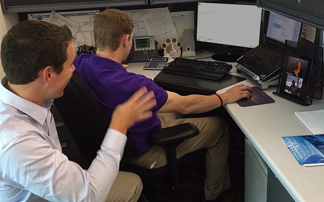 John Slone (left) and Jon Mowl of DLA Finance use the virtual remote interpreting service via tablet. The service is being tested at DLA Headquarters as a tool to improve communication for deaf employees. 