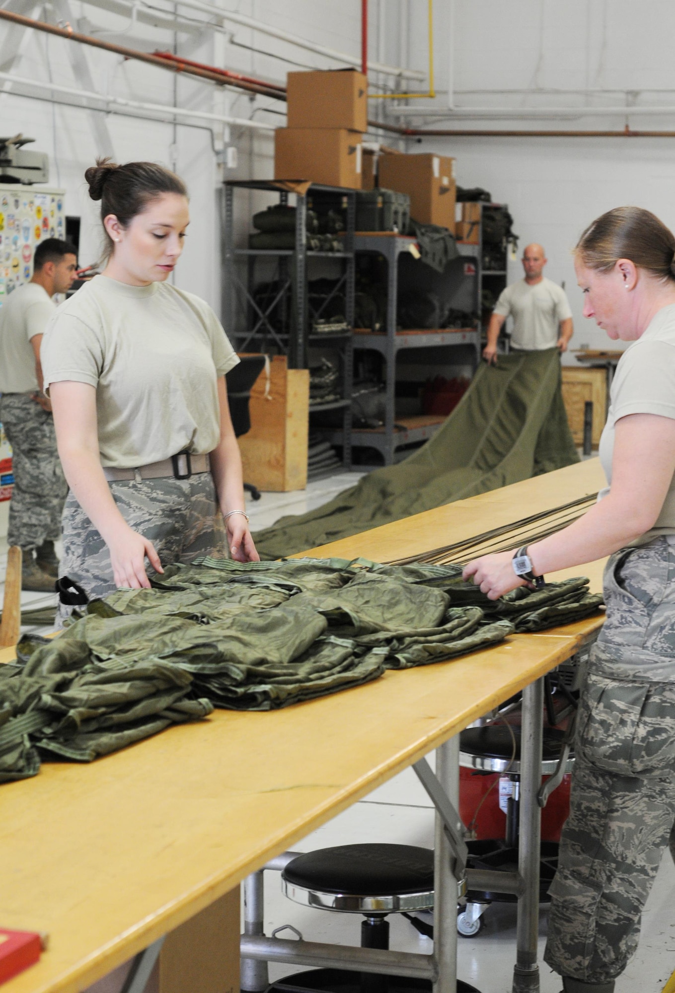 Airman 1st Class Stephanie Dutton and Senior Airman Robyn Miller, Air Transportation Specialists assigned to 103rd Airlift Wing, Bradley Air National Guard Base, Connecticut, pack a parachute canopy during the C-130 Roundup here, Aug. 24. The Round-Up is a friendly skills competition for aircrew members and aerial porters, with events in cargo loading and unloading, aerial cargo drops, combat landings and formation flying. (U.S. Air Force photo/Staff Sgt. Rachel Kocin)