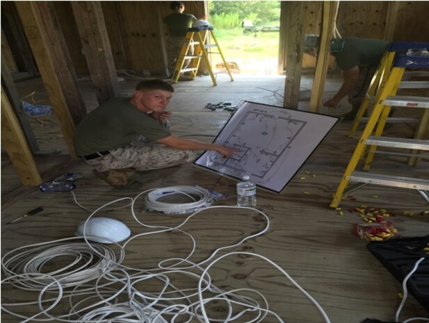 Sgt. Hubberstey, a student with Advanced Electrician course 3-15, goes over interior wiring plans inside of a South West Asia (SWA) hut at BB-50 at Marine Corps Engineer School, Utilities Instruction Company, Courthouse Bay, Camp Lejeune, North Carolina.  This course ensures that Non-Commissioned Officers within this Military Occupational Specialty understand how to inspect their Marines interior wiring and correct deficiencies in accordance with the National Electrical Code.  
