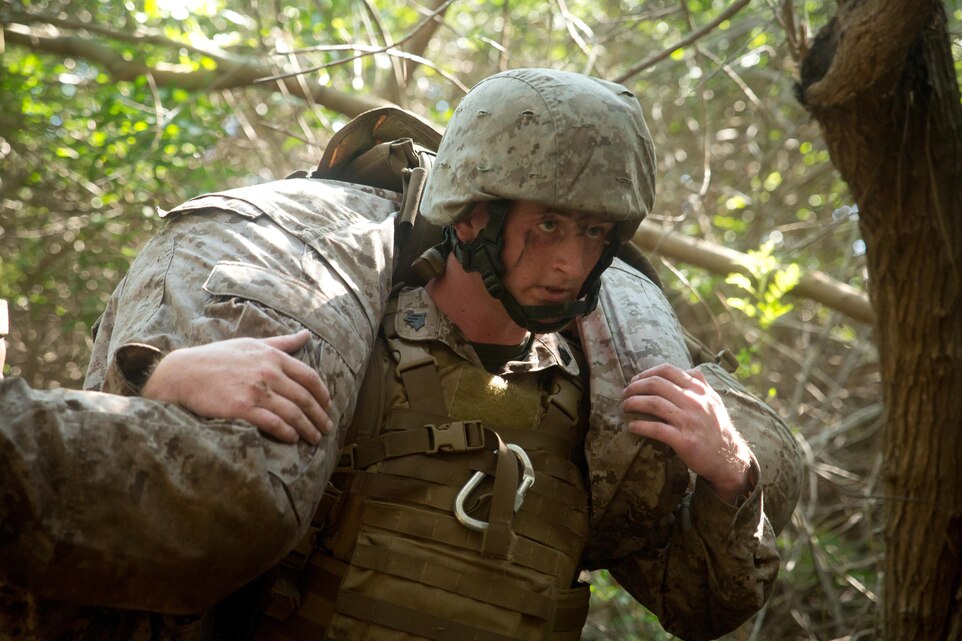 Sgt. Mark Berger, a cyber network operator with Headquarters Company, 3rd Marine Regiment, and a Sulligent, Ala., native, fireman carries a simulated casualty during Sergeants Course aboard Marine Corps Base Hawaii Aug 19, 2015. The squad Berger was in was ambushed resulting in a Marine becaming a simulated casualty in the scenario. Sergeants Course is a vital part of professional military education for any Marine and helps to maintain the standards amongst the NCOs of the Marine Corps. The course supports MCB Hawaii’s mission, which is to provide facilities, programs and services in direct support of units, individuals and families to enhance and sustain combat readiness for all operating forces and tenant organizations aboard the installation. (U.S. Marine Corps photo by Cpl. Khalil Ross/Released)