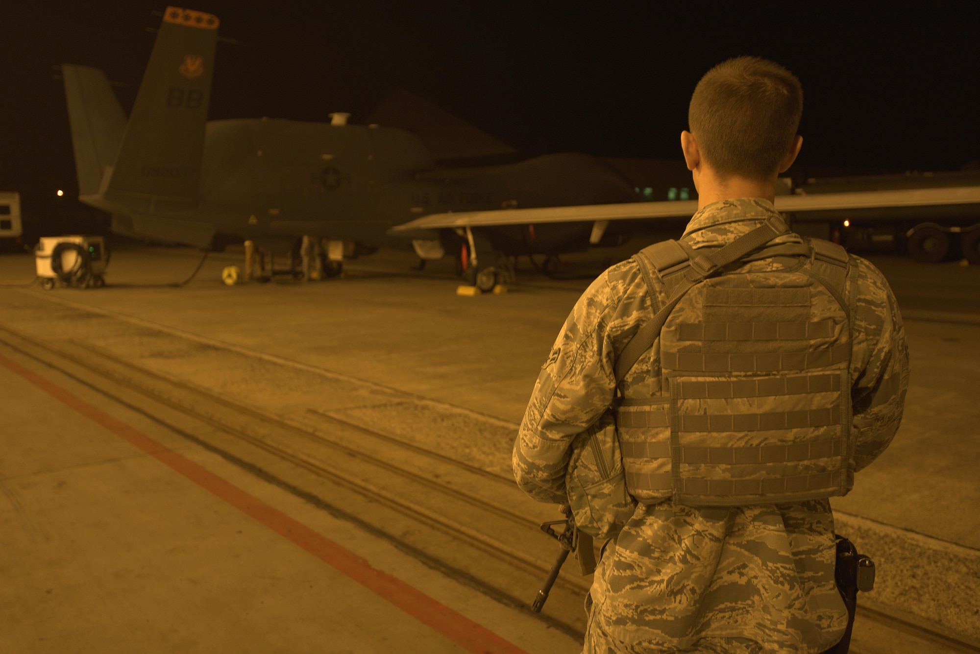 U.S. Air Force Airman 1st Class Caleb Kenley, 35th Security Forces Squadron installation entry controller, oversees the security of a RQ-4 Global Hawk at Misawa Air Base, Japan, Aug. 19, 2015. During the RQ-4’s six-month rotation to Misawa, direct safety and security is provided to ensure the aircraft is protected and ready to perform its mission. (U.S. Air Force photo by Senior Airman Jose L. Hernandez-Domitilo/Released)