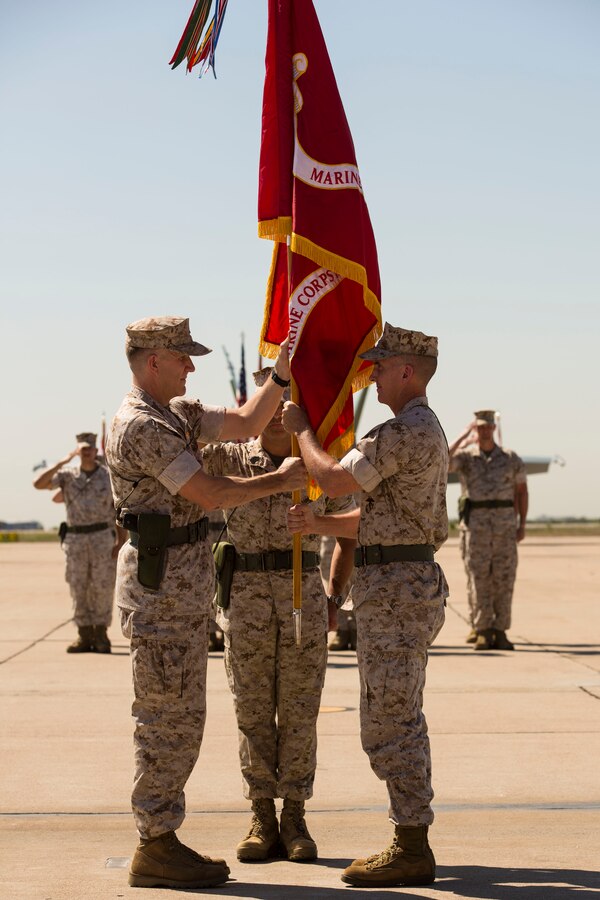 Col. Jason Woodworth, left, commanding officer of Marine Corps Air Station Miramar, California, recieves the air station's colors from Col. John Farnam during a change of command ceremony aboard the air station, Aug. 28. The passing of the colors is a military tradition symbolizing the transfer of authority and responsibility for the station from one commander to another.