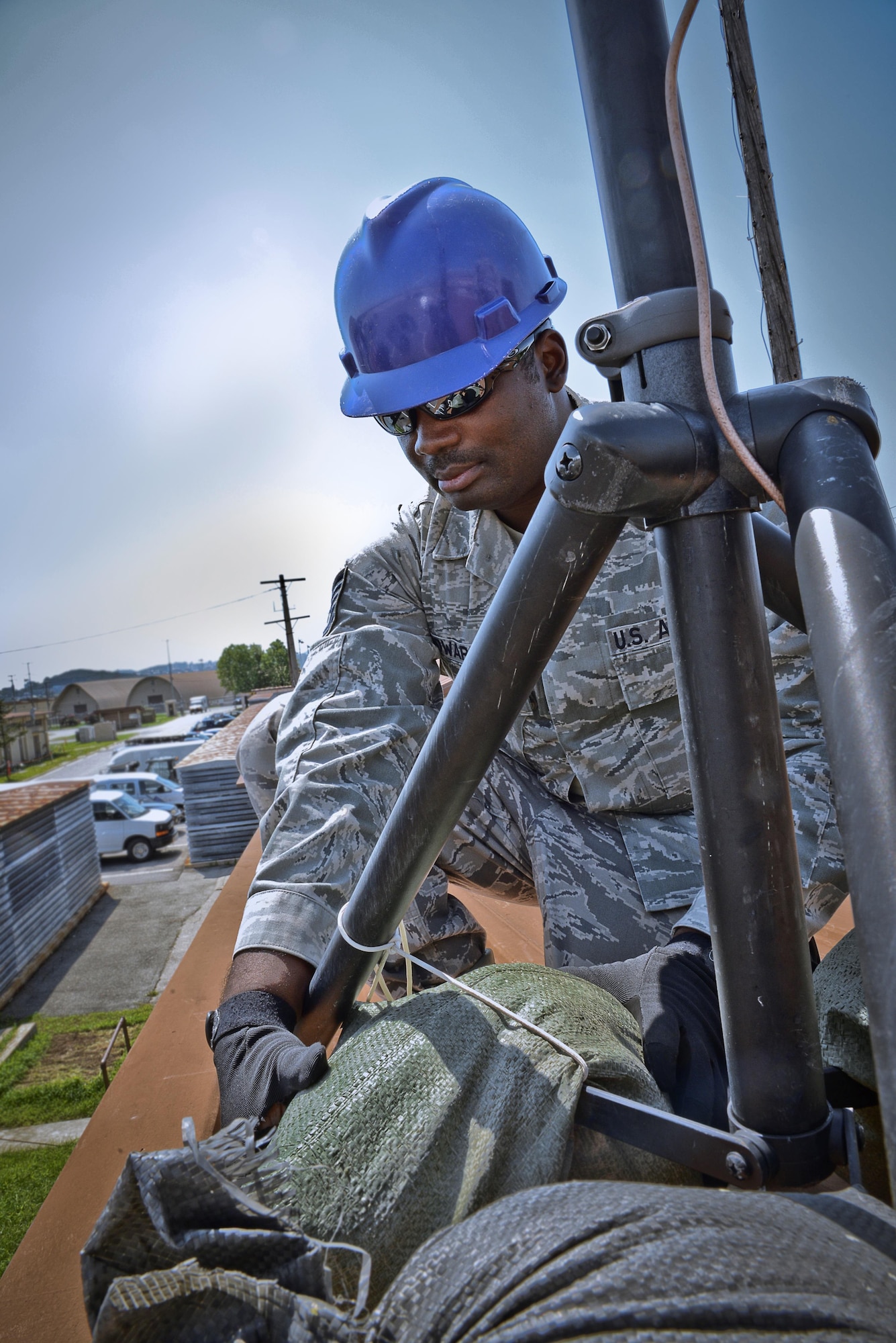 Tech. Sgt. Olandre L. Edwards, 644th Combat Communications Squadron radio frequency transmissions supervisor, adjusts sand bags on an antenna stand as part of a preventative-maintenance inspection to ensure reliable radio communications are maintained. The 644th CBCS is in place at Suwon Air Base, Japan, from Anderson Air Force Base, Guam, to help set up and maintain temporary communications. (U.S. Air Force photo by Tech. Sgt. Travis Edwards-Released/Released)